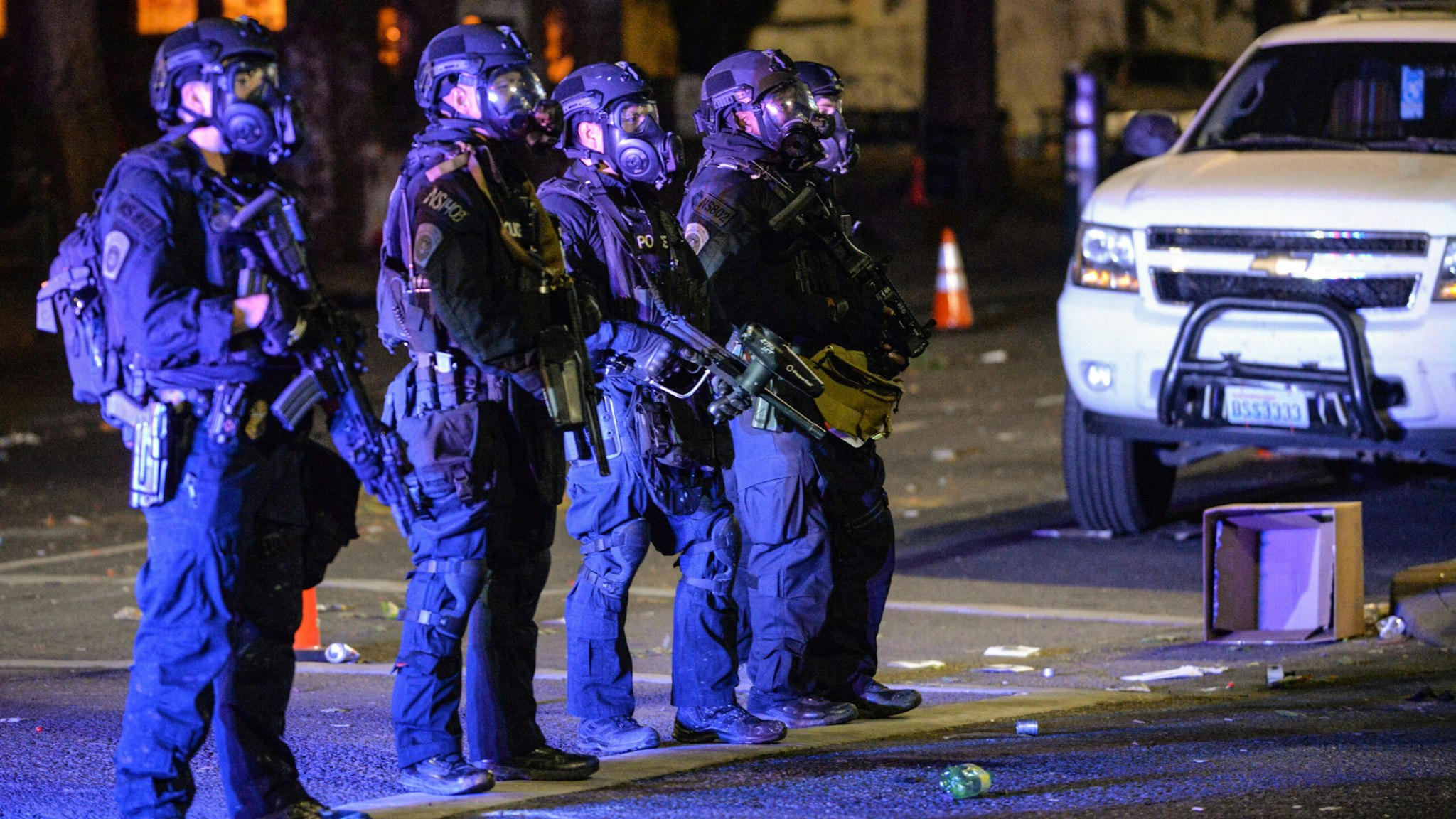 Security officials form a line across a street in Portland, Oregon early July 26, 2020, as protests continue across the United States following the death in Minneapolis of unarmed African-American George Floyd. - Police and federal agents fired tear gas and forcefully dispersed protesters in the US city of Portland, amid President Donald Trump's heavily-criticized "surge" of security forces to major cities. The city, the biggest in the state of Oregon, has seen nightly protests against racism and police brutality for nearly two months, initially sparked by the death of unarmed African American George Floyd at the hands of police in Minnesota