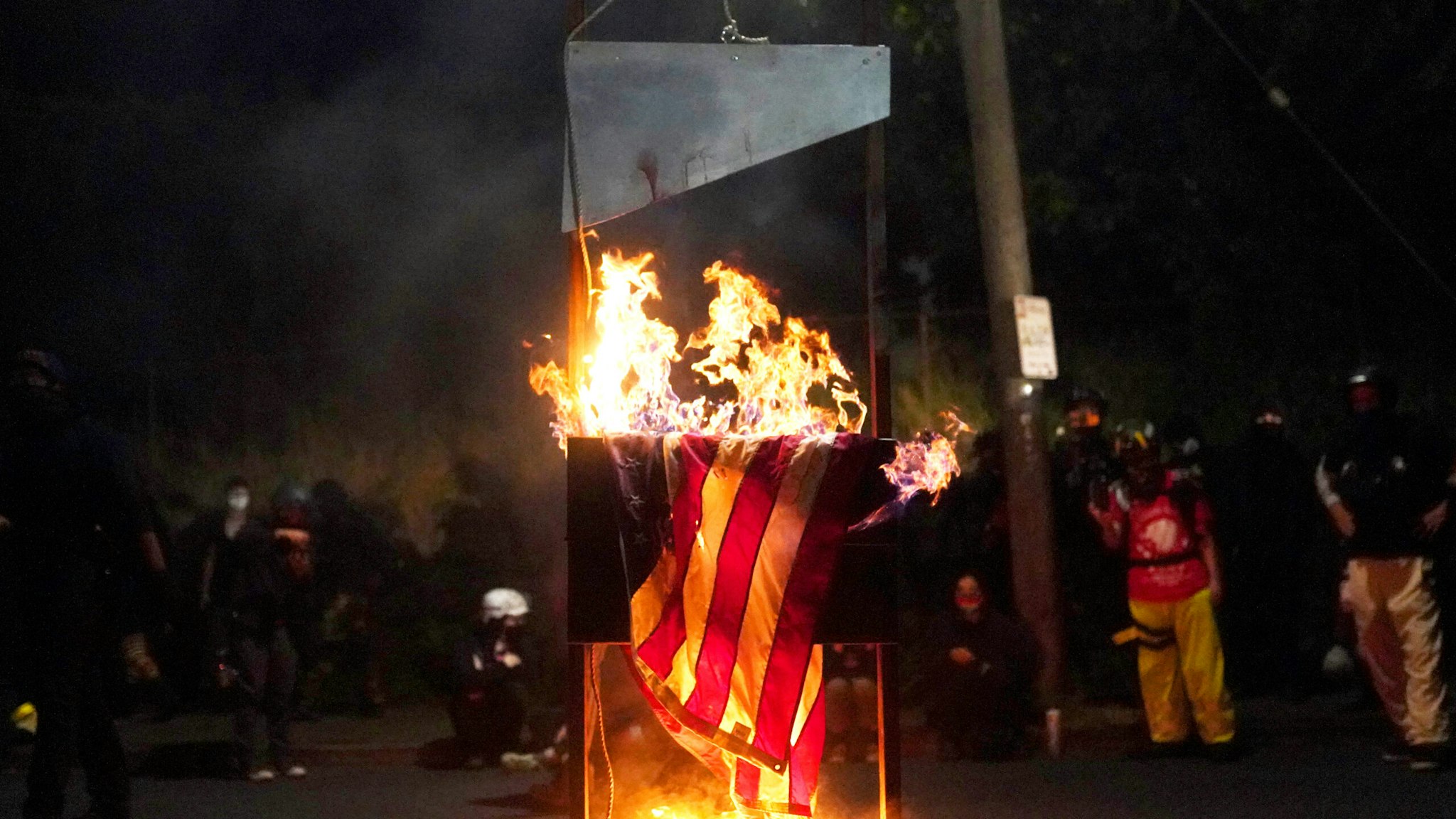 PORTLAND, OR - AUGUST 22: An American flag burns in front of the Multnomah County Sheriffs Office on August 22, 2020 in Portland, Oregon. Hundreds of protesters clashed with police Saturday night following a rally in east Portland.