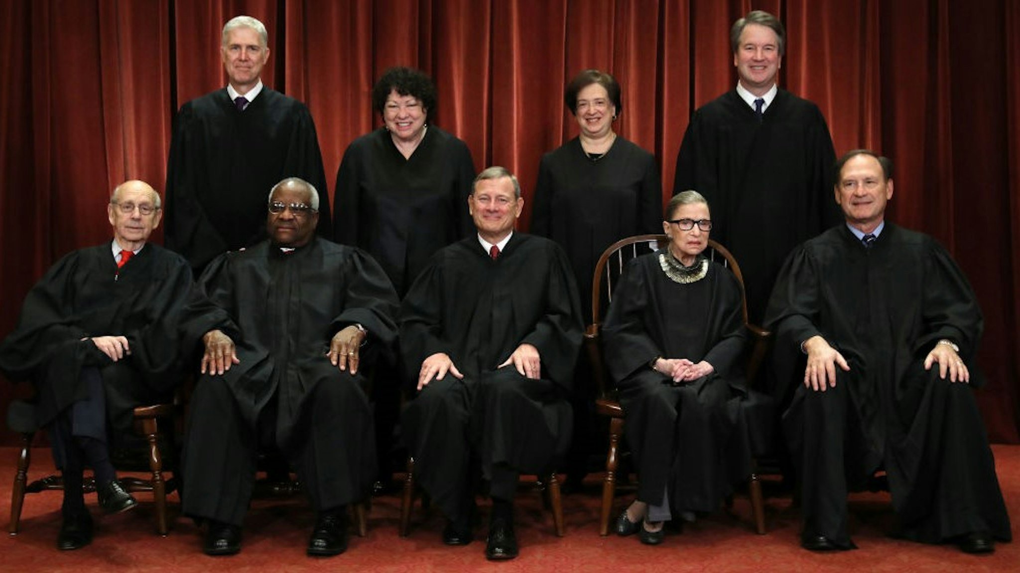 WASHINGTON, DC - NOVEMBER 30: United States Supreme Court (Front L-R) Associate Justice Stephen Breyer, Associate Justice Clarence Thomas, Chief Justice John Roberts, Associate Justice Ruth Bader Ginsburg, Associate Justice Samuel Alito, Jr., (Back L-R) Associate Justice Neil Gorsuch, Associate Justice Sonia Sotomayor, Associate Justice Elena Kagan and Associate Justice Brett Kavanaugh pose for their official portrait at the in the East Conference Room at the Supreme Court building November 30, 2018 in Washington, DC. Earlier this month, Chief Justice Roberts publicly defended the independence and integrity of the federal judiciary against President Trump after he called a judge who had ruled against his administration’s asylum policy “an Obama judge.” “We do not have Obama judges or Trump judges, Bush judges or Clinton judges,” Roberts said in a statement. “What we have is an extraordinary group of dedicated judges doing their level best to do equal right to those appearing before them. That independent judiciary is something we should all be thankful for.” (Photo by