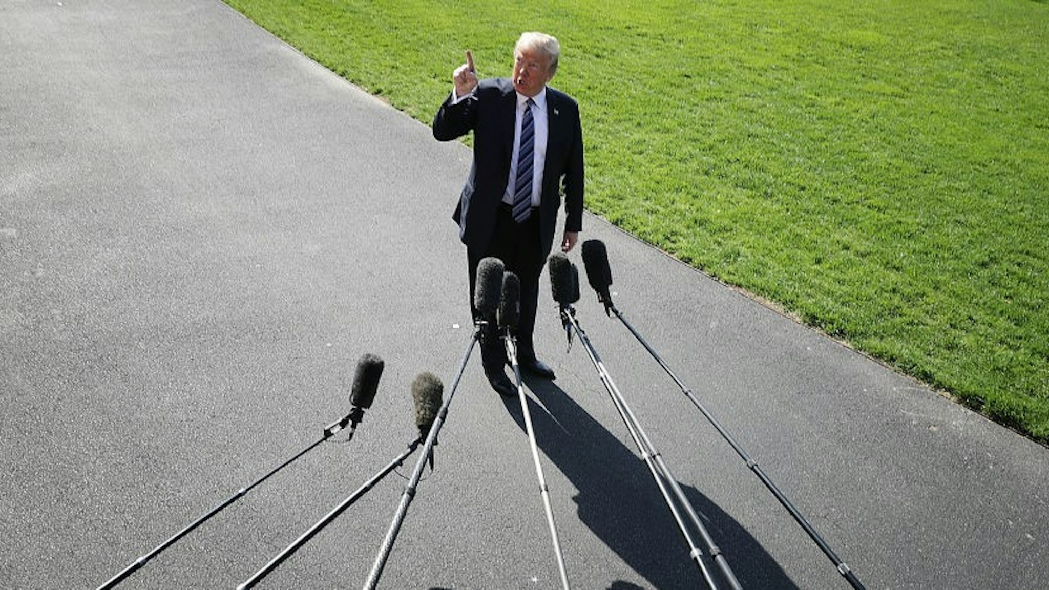 WASHINGTON, DC - MAY 25: U.S. President Donald Trump points up to the second floor of the White House and tells members of the news media that first lady Melania Trump is watching him depart the White House May 25, 2018 in Washington, DC. Trump is traveling to Annapolis, Maryland, to participate in the Naval Academy's graduation ceremony. (Photo by