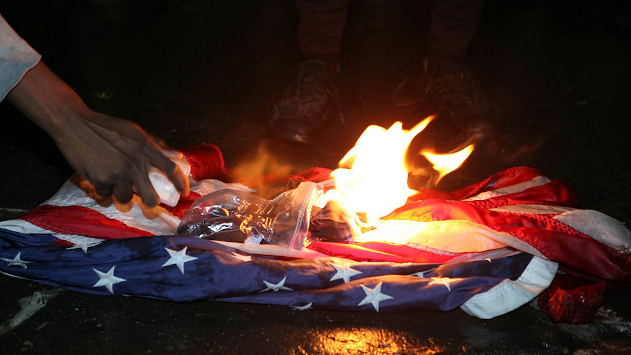 NEW YORK - NOVEMBER 9: Protesters burn the Stars and Stripes American Flag outside Trump Tower as Donald Trump is elected President on November 9, 2016 in New York City. (Ruaridh Connellan/BarcroftImages / Barcroft Media via Getty Images)