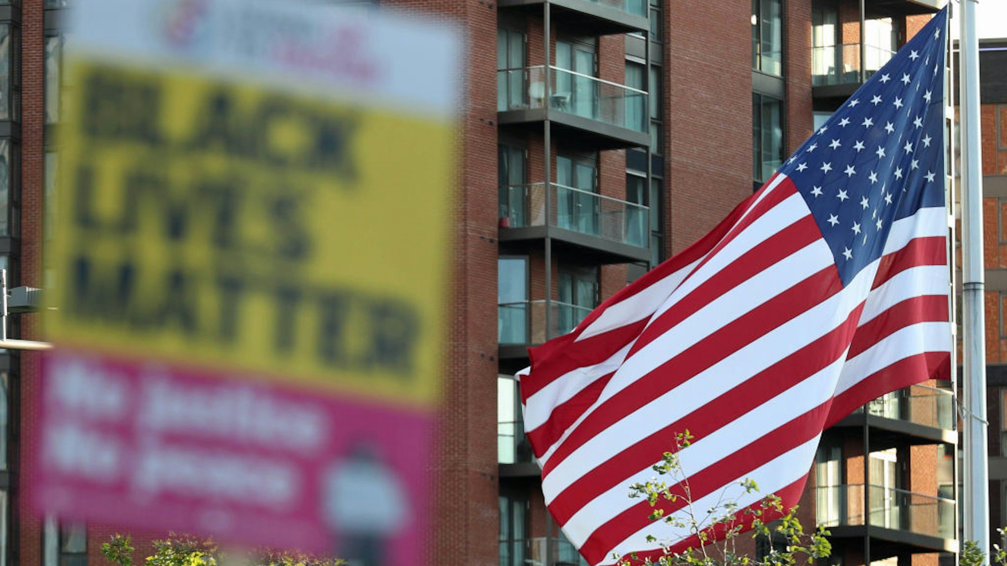 Black Lives Matter placard alongside the American flag during an anti-racism demonstration coinciding with the start of the trial of the four police officers charged with the murder of George Floyd in the US. (Photo by Yui Mok/PA Images via Getty Images)