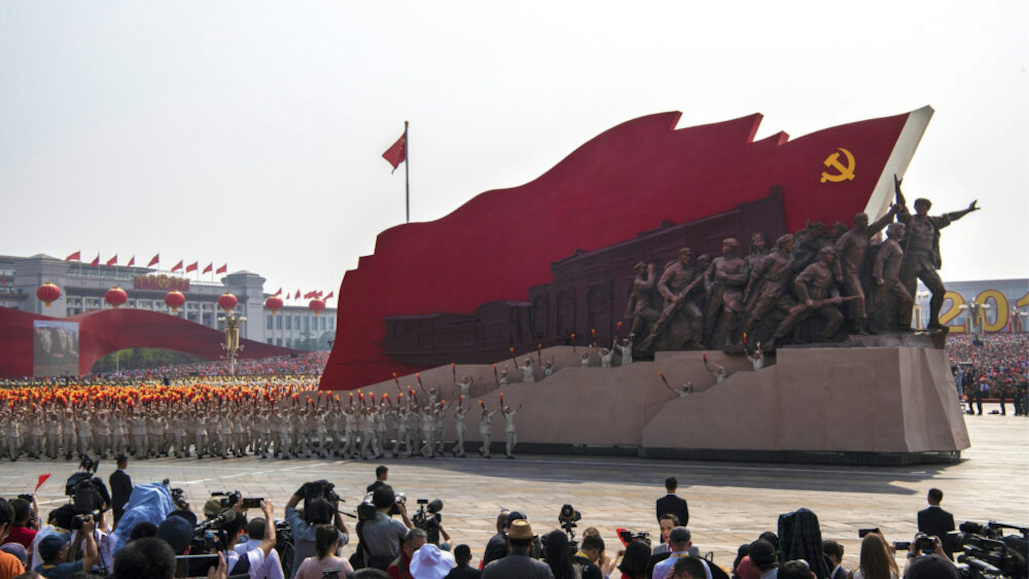 BEIJING, CHINA - OCTOBER 01: Chinese participants walk beside a Communist Party float at a parade to celebrate the 70th Anniversary of the founding of the People's Republic of China in 1949, at Tiananmen Square on October 1, 2019 in Beijing, China.