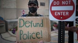 Defund the Police A small group of peaceful demonstrators protesting the shooting of Jacob Blake hold a rally on August 28, 2020 in Kenosha, Wisconsin. Blake was shot seven times in the back in front of his three children by a police officer. The shooting has led to several days of rioting and protests in the city. (Photo by Scott Olson/Getty Images)