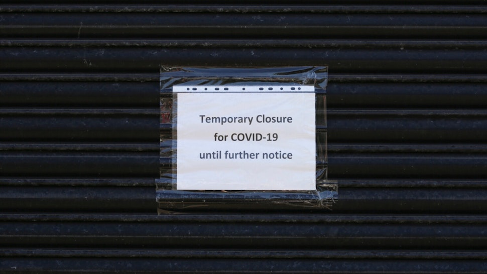 Sign on anonymous shuttered building saying ‘Temporary closure for Covid 19’ during the Covid 19 coronavirus pandemic.