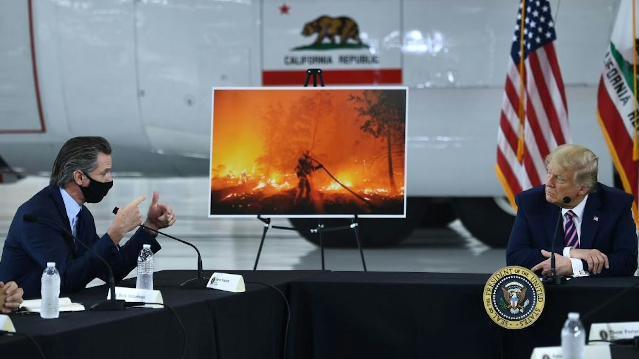 US President Donald Trump(R) speaks to California Governor Gavin Newsom(D-CA) at Sacramento McClellan Airport in McClellan Park, California on September 14, 2020 during a briefing on wildfires. (Photo by Brendan Smialowski / AFP)