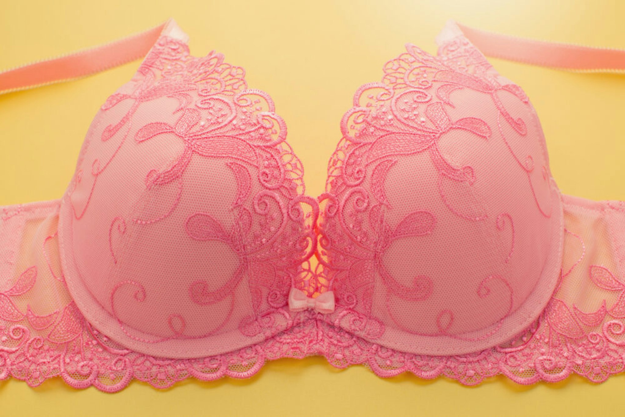 Close-Up Of Pink Bra Against Yellow Background - stock photo