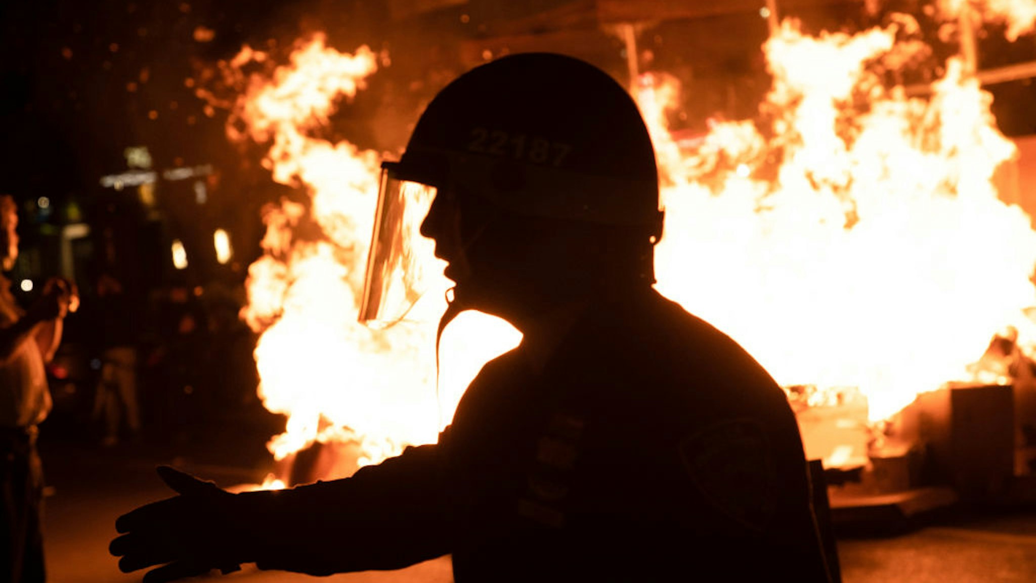 Police officers force protesters off the street after a fire was lit during an anti police brutality march in Manhattan.