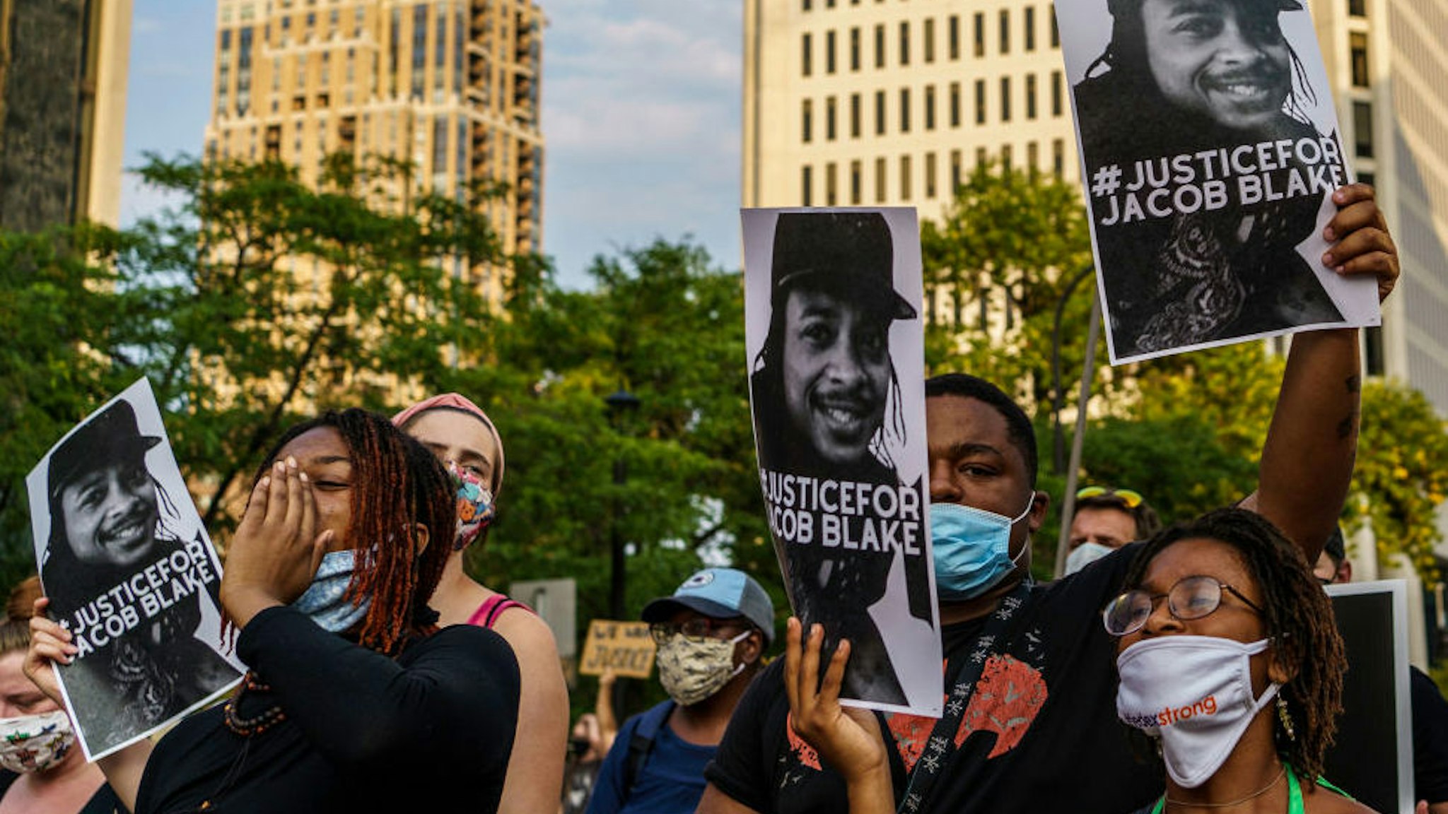 Protesters hold signs outside the Minneapolis 1st Police precinct during a demonstration against police brutality and racism on August 24, 2020 in Minneapolis, Minnesota.