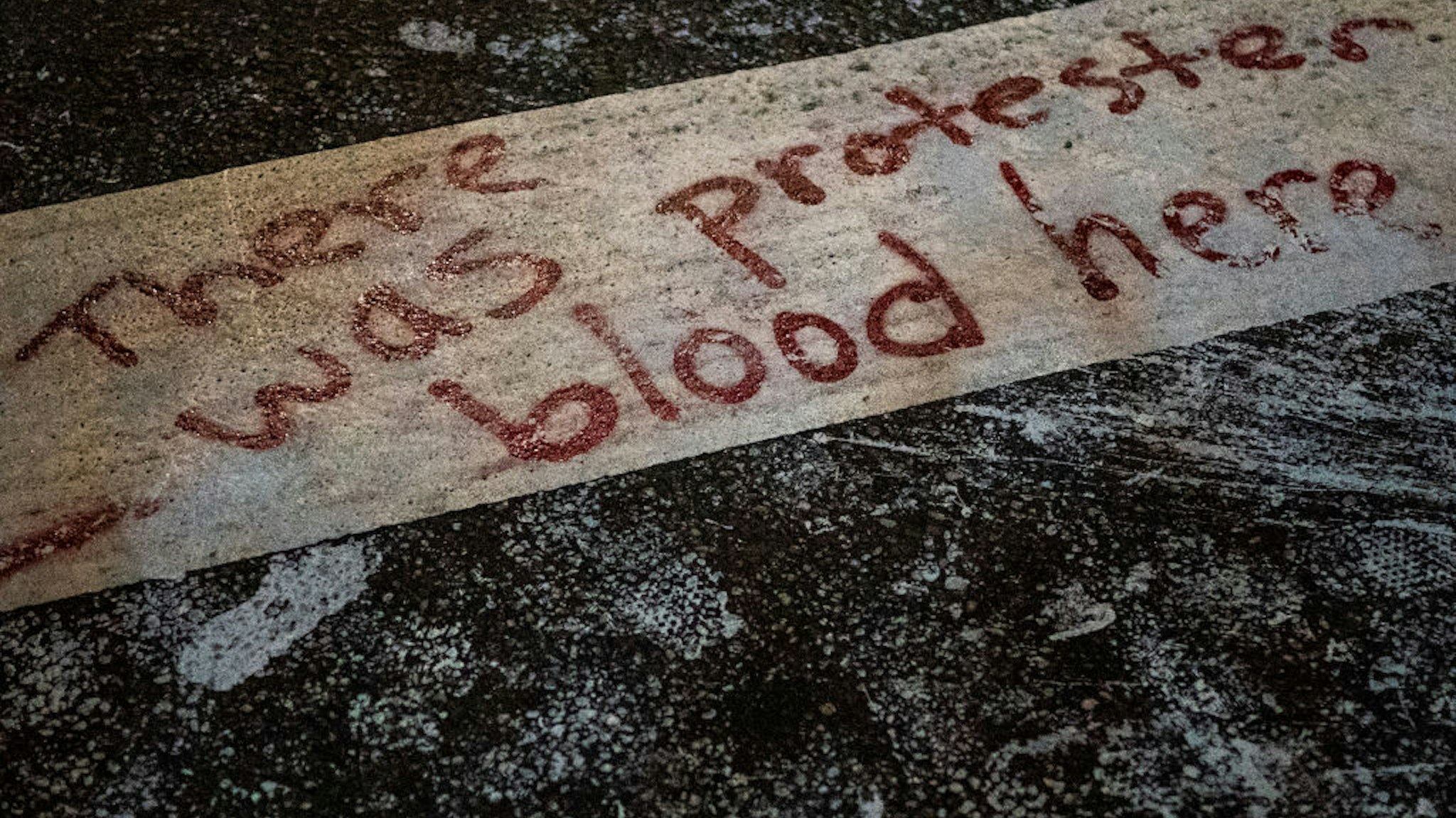 PORTLAND, OR - SEPTEMBER 5: The words There was protester blood here are seen here in a crosswalk after Portland police injured a woman during an arrest early in the morning on September 5, 2020 in Portland, Oregon. Friday night marked the 99th night of protests in Portland following the death of George Floyd in police custody. (Photo by Nathan Howard/Getty Images)