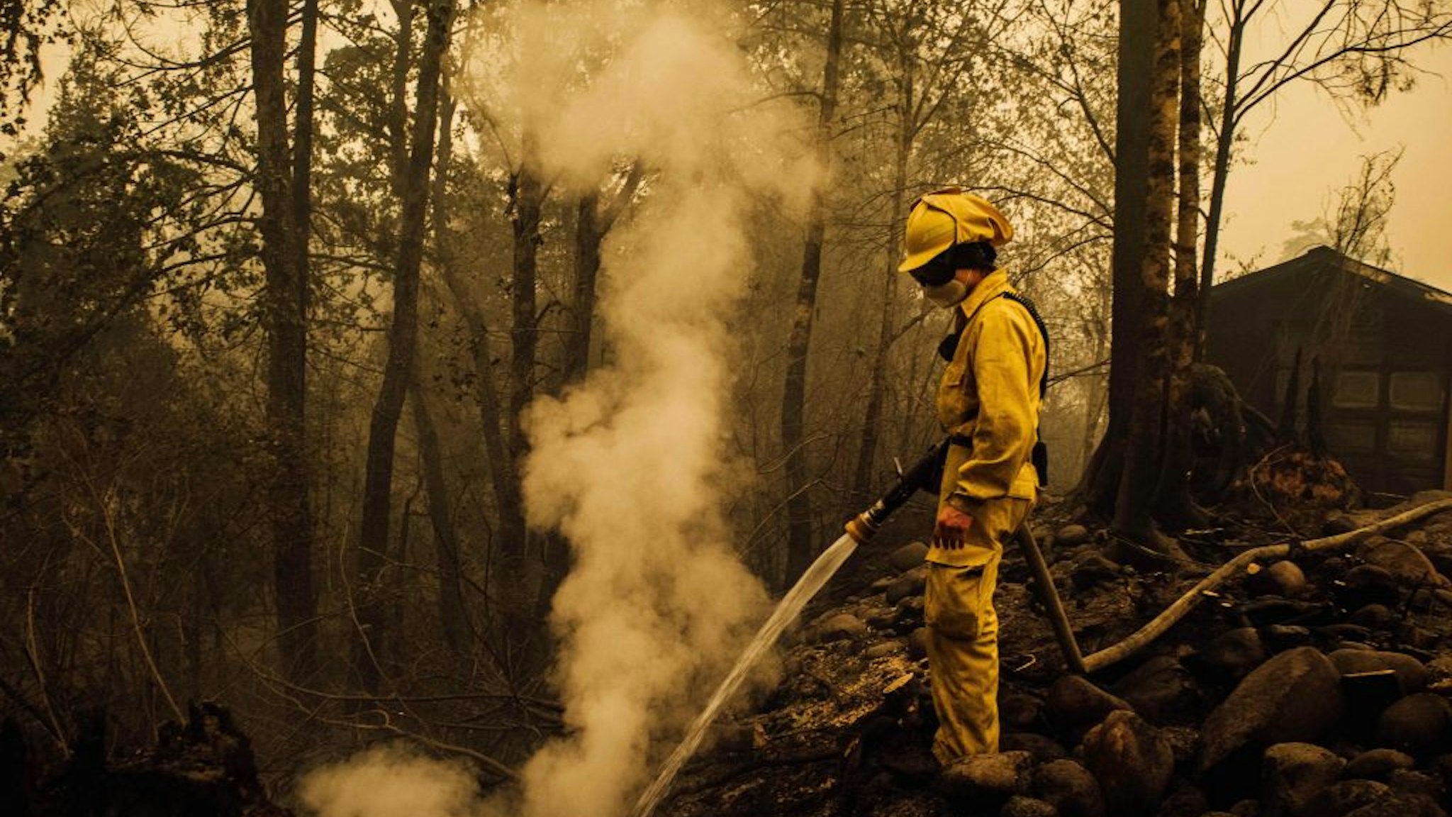 Volunteer firefighter Jacob Ruthrock puts out embers from a fire in Gates, Oregon, on September 10, 2020. - California firefighters battled the state's largest ever inferno on September 10, as tens of thousands of people fled blazes up and down the US West Coast and officials warned the death toll could shoot up in coming days. At least eight people have been confirmed dead in the past 24 hours across California, Oregon and Washington, but officials say some areas are still impossible to reach, meaning the number is likely to rise. (Photo by Kathryn ELSESSER / AFP) (Photo by KATHRYN ELSESSER/AFP via Getty Images)