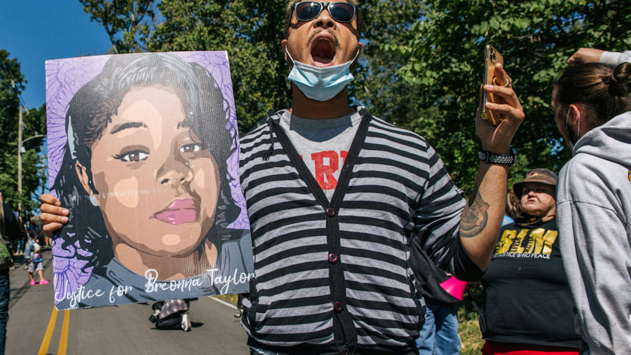 A demonstrator holds up a sign of Breonna Taylor while chanting during a protest in wake of Supreme Court Justice Ruth Bader Ginsburgs death in front of Senate Majority Leader Sen. Mitch McConnells home on September 19, 2020 in Louisville, Kentucky.