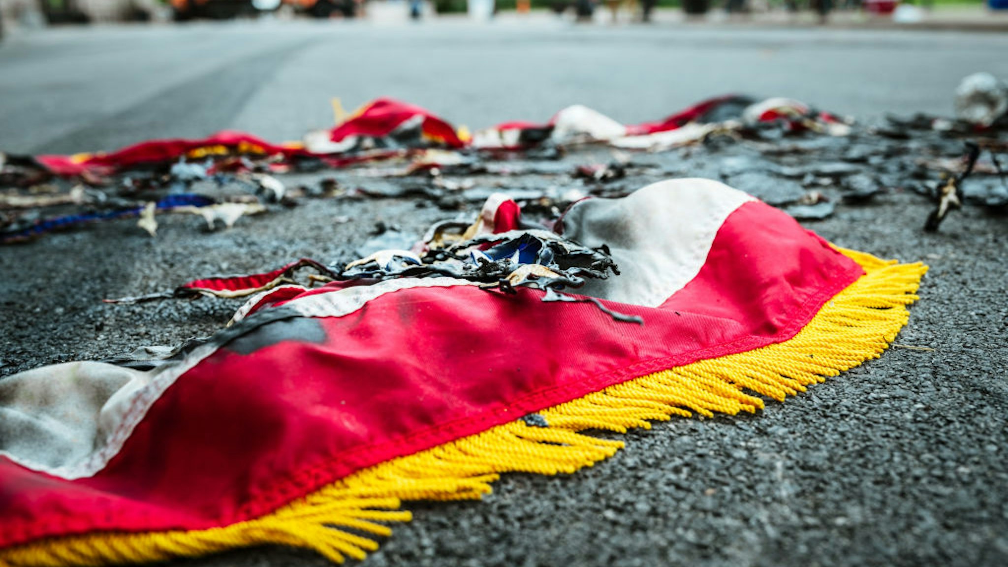 LOUISVILLE, KY - SEPTEMBER 22: The remnants of an American flag sit charred on the road near Jefferson Square Park on September 22, 2020 in Louisville, Kentucky. Jefferson Square Park has remained the epicenter for Louisville protest action following the March 13th killing of Breonna Taylor by police during a no-knock warrant at her apartment. (Photo by Jon Cherry/Getty Images)