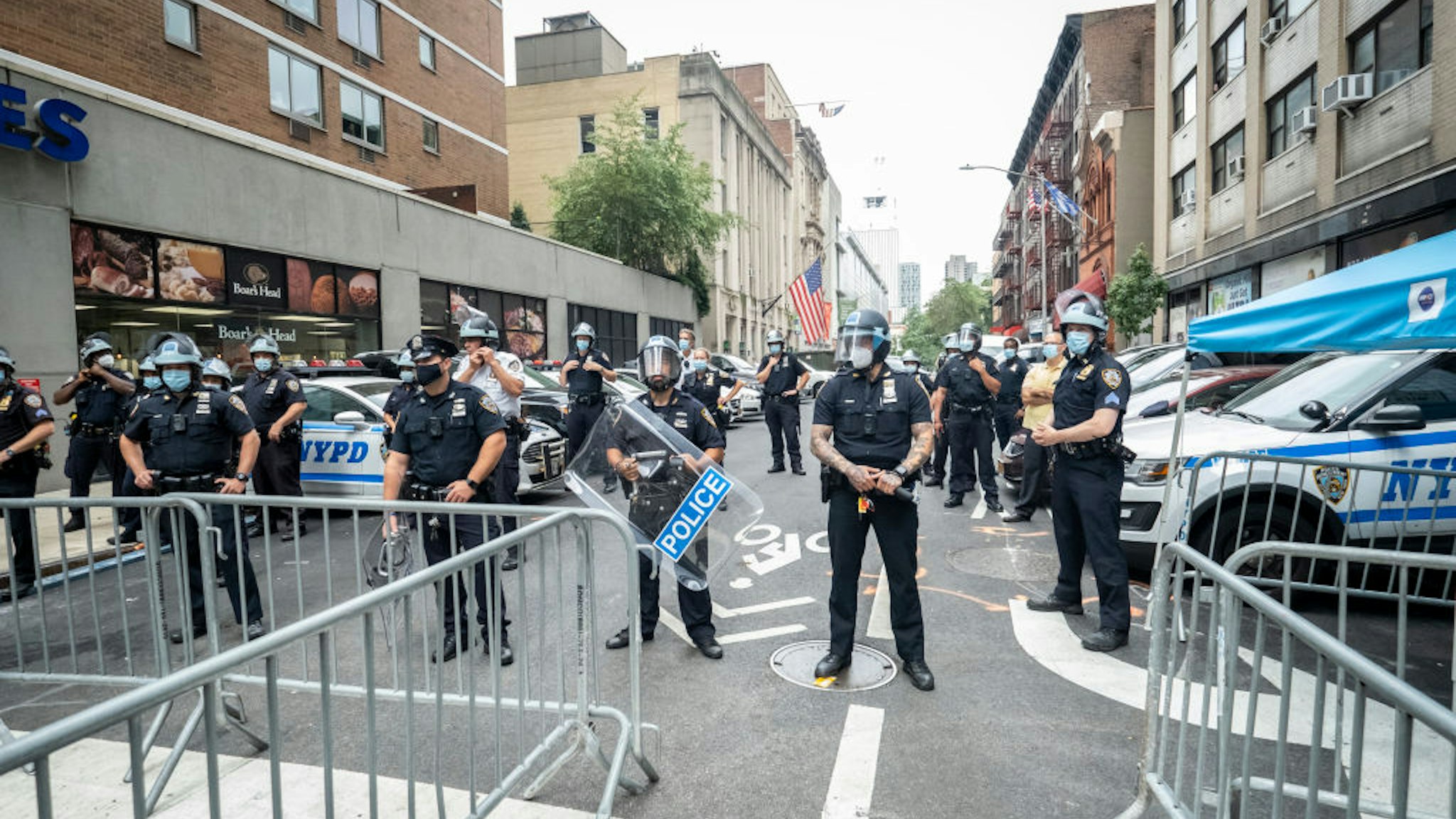 A line of police in protective helmets and riot shields wait to meet Derrick Ingram and supporters on August 08, 2020 in the Manhattan borough of New York City.