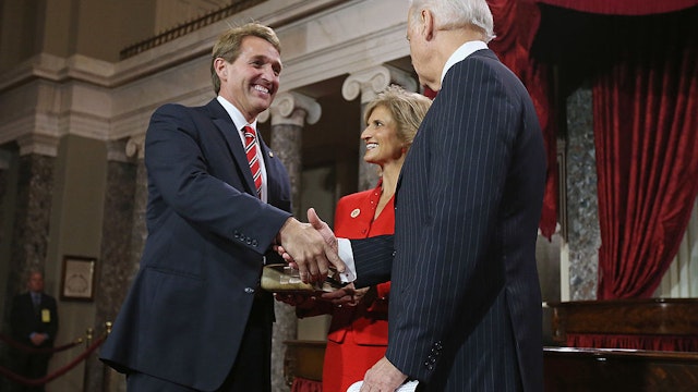 U.S. Sen. Jeff Flake (R-AZ) (L) participates in a reenacted swearing-in with his wife Cheryl Flake (C) and U.S. Vice President Joe Biden in the Old Senate Chamber at the U.S. Capitol January 3, 2013 in Washington, DC.