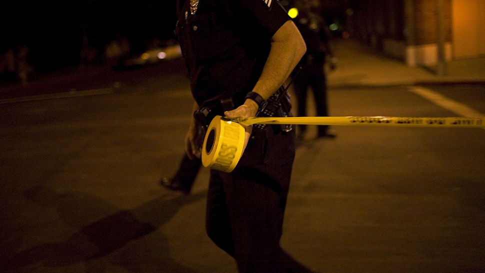 OS ANGELES - SEPTEMBER 14: Los Angeles Police Department gang unit officers tape off a Crime Scene Investigation area following the shooting of a man September 14, 2007 in the Northeast precinct of Los Angeles, California. The injured man was taken to a nearby hospital after his assailant escaped. Police detectives questioned the victim's girlfriend, who arrived after the shooting, when a pistol was found inside her car. The LAPD gang unit is part of the Rampart police precinct where MS-13 and Hispanic street gangs have plagued local neighborhoods for decades. (Photo by Robert Nickelsberg/Getty Images)