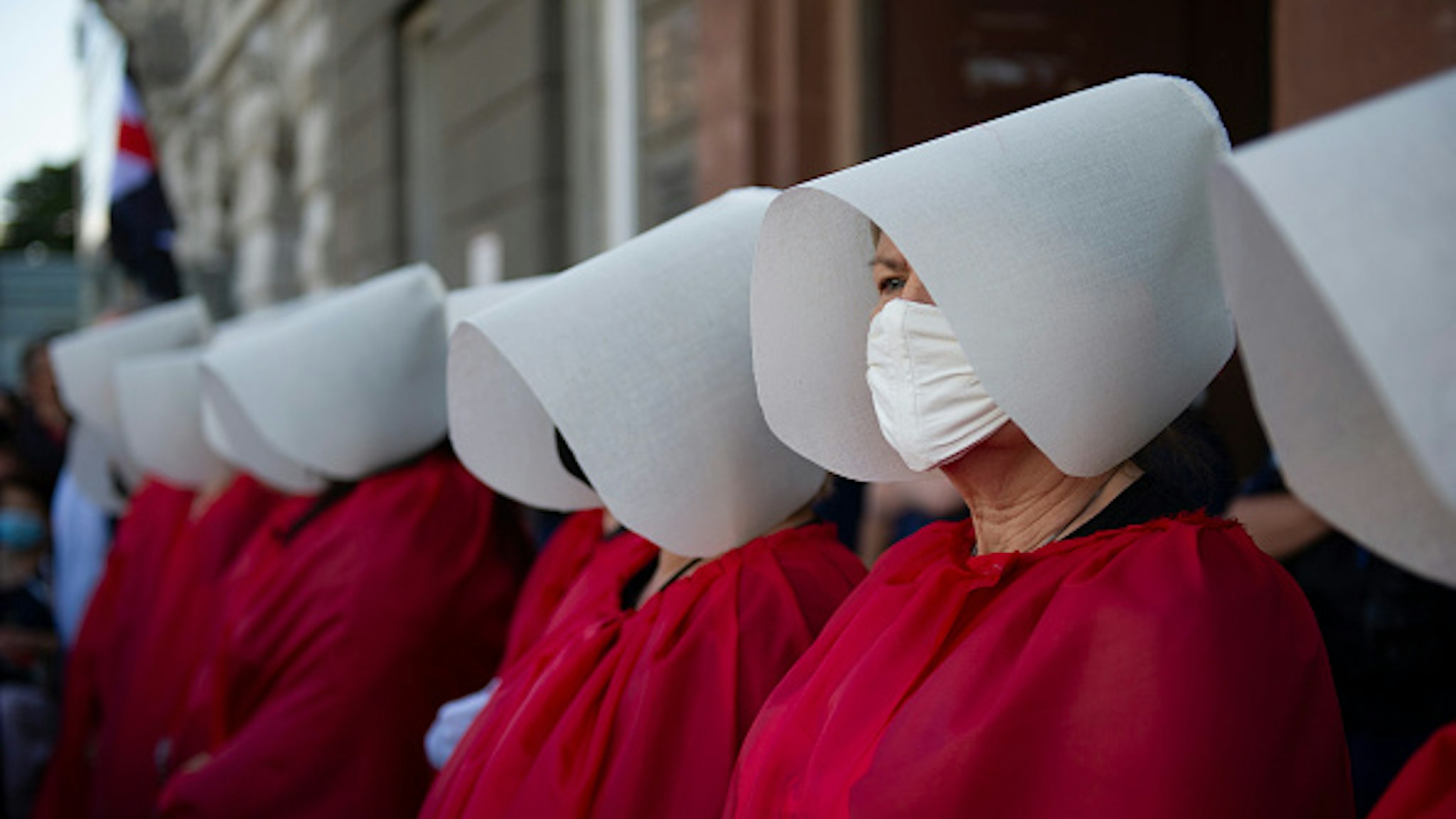 Demonstrators wearing protective face masks are dressed as the Handmaids from the dystopian novel The Handmaid's Tale from the Canadian author Margaret Atwood perform during an anti-domestic violence protest on July 24, 2020 in Warsaw, Poland. Thousands of demonstrators took part in a protest against government plan to pull out of an international treaty on preventing and combating domestic violence.