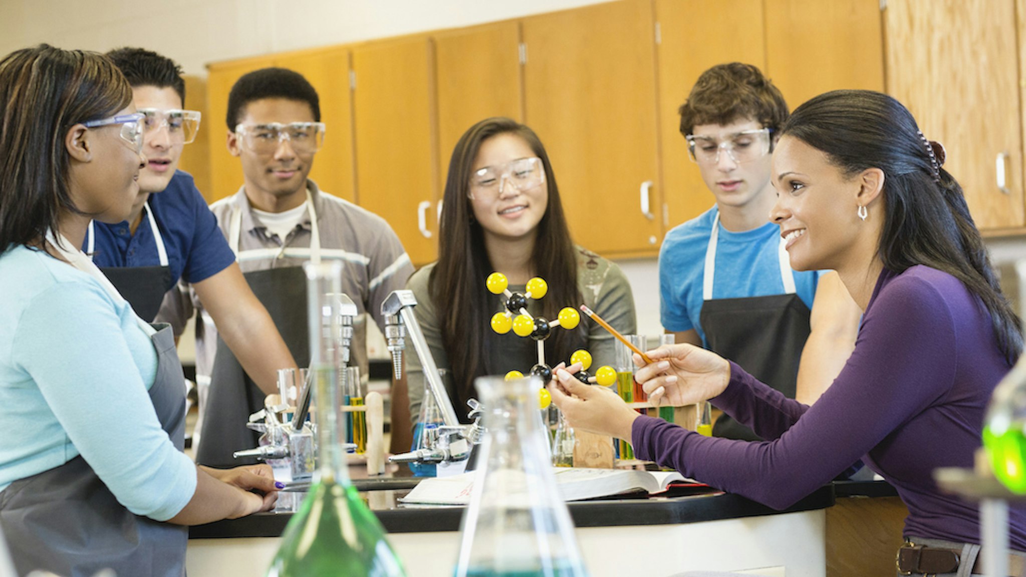 Teacher explaining chemistry model to students (Jon Feingersh Photography Inc/Getty Images)
