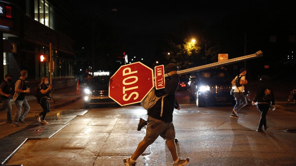 A demonstrator carries a traffic stop sign while marching during a protest in Louisville, Kentucky, U.S., on Thursday, Sept. 24, 2020. Wednesday's decision not to charge Kentucky police officers for the killing of Breonna Taylor ignited a fresh wave of protests in the U.S. Photographer: Luke Sharrett/Bloomberg via Getty Images