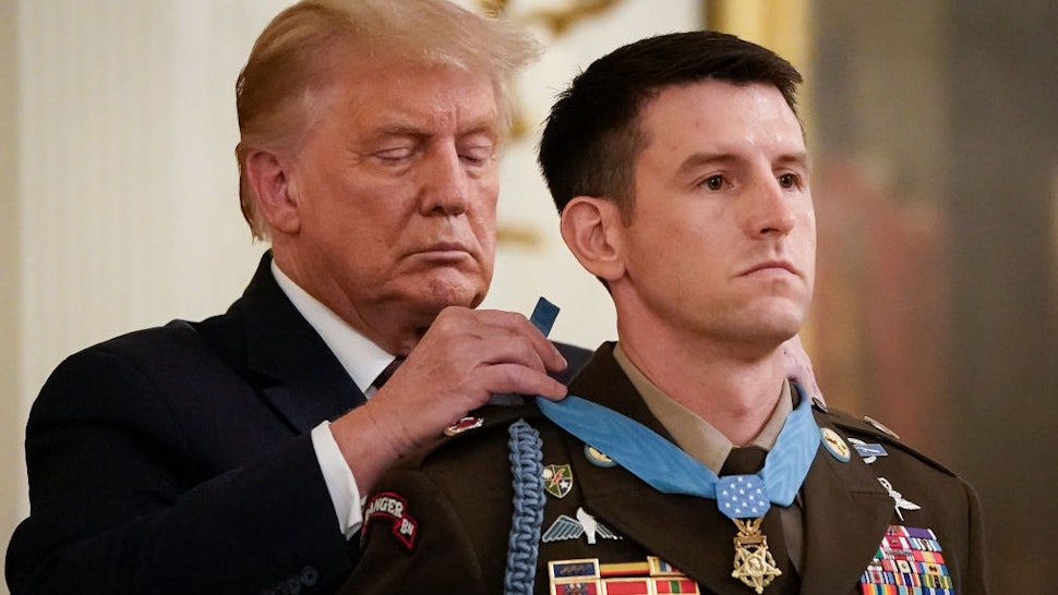 WASHINGTON, DC - SEPTEMBER 11: U.S. President Donald Trump presents the Medal of Honor to Sergeant Major Thomas P. Payne, United States Army, for conspicuous gallantry in the East Room of the White House on September 11, 2020 in Washington, DC. On October 22, 2015, during a daring nighttime hostage rescue in Kirkuk Province, Iraq, then-Sergeant First Class Payne led a combined assault team charged with clearing one of two buildings known to house hostages. His actions were key to liberating 75 hostages during a rescue mission that resulted in 20 enemy fighters killed in action.