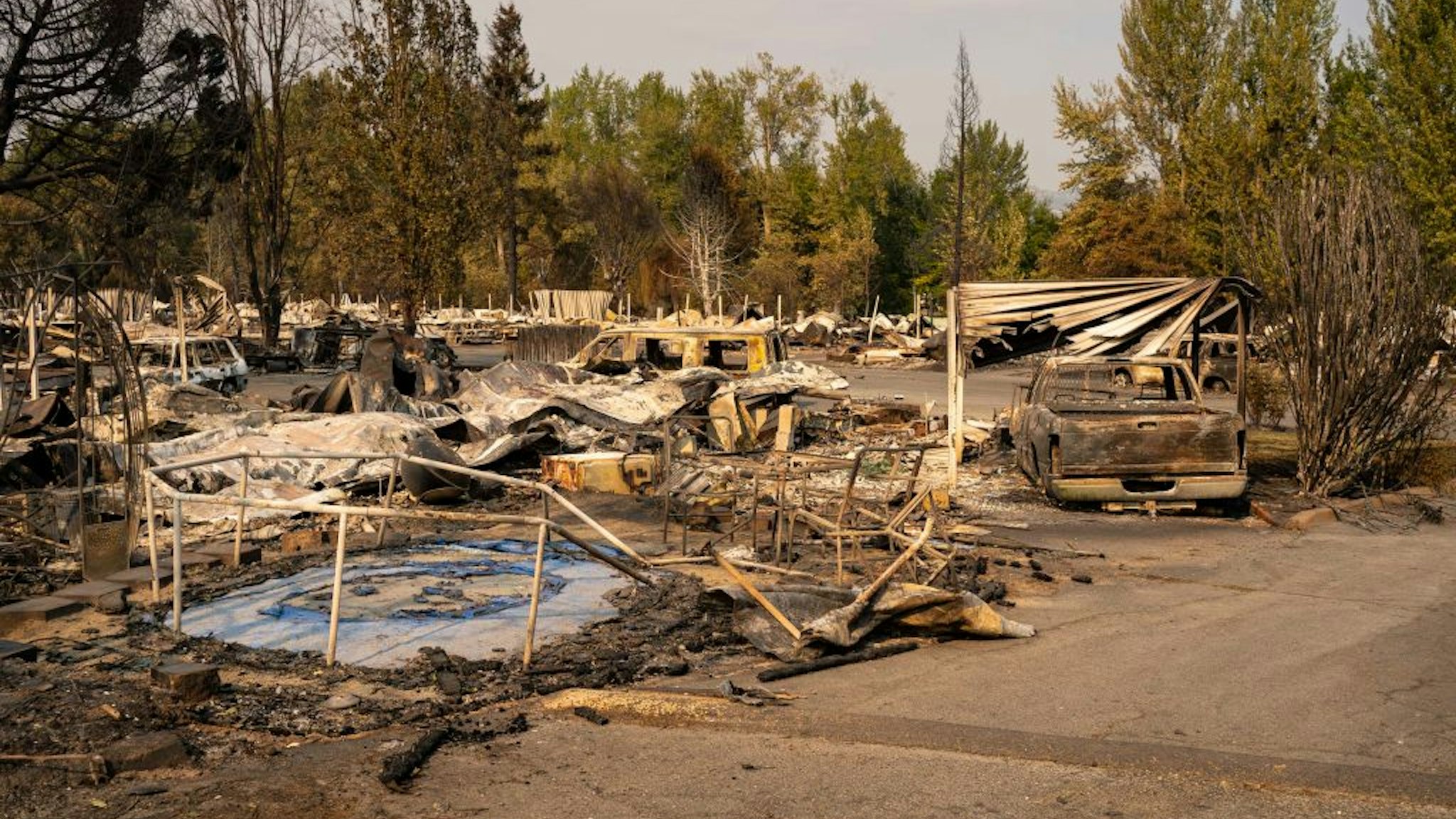 PHOENIX, OR - SEPTEMBER 10: A damaged trampoline sits in a mobile home park destroyed by fire on September 10, 2020 in Phoenix, Oregon. Hundreds of homes in the town have been lost due to wildfire.