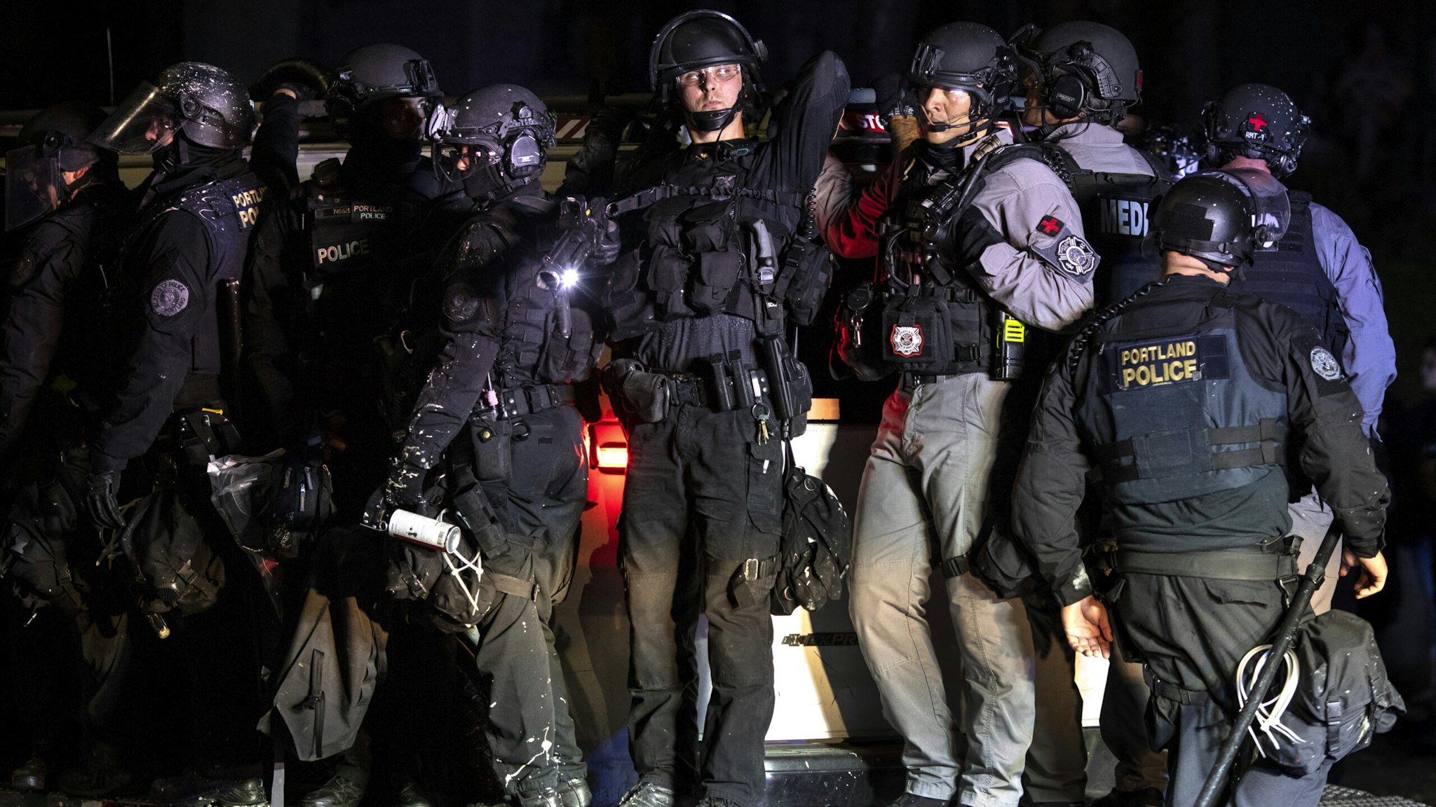 Portland police are seen in riot gear during a standoff with protesters in Portland, Oregon on August 16, 2020. Protests have continued for the 80th consecutive night in Portland since the killing of George Floyd.