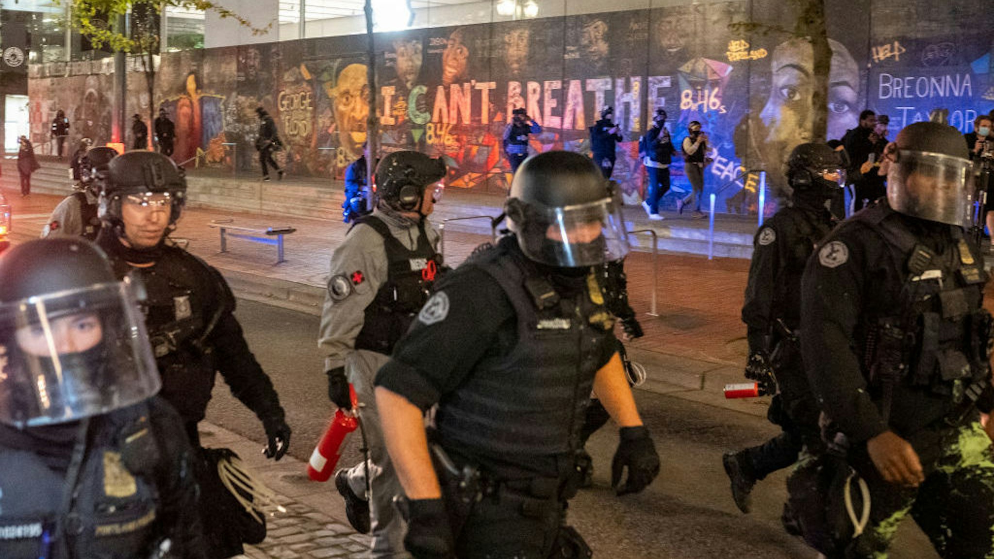 Portland police disperse a crowd of protesters past a mural of George Floyd and Breonna Taylor on September 26, 2020 in Portland, Oregon. Oregon Governor Kate Brown declared a state of emergency prior to Saturday's protest and Proud Boy rally, as fears of political violence between far-right groups and Black Lives Matter protesters grew. (Photo by Nathan Howard/Getty Images)