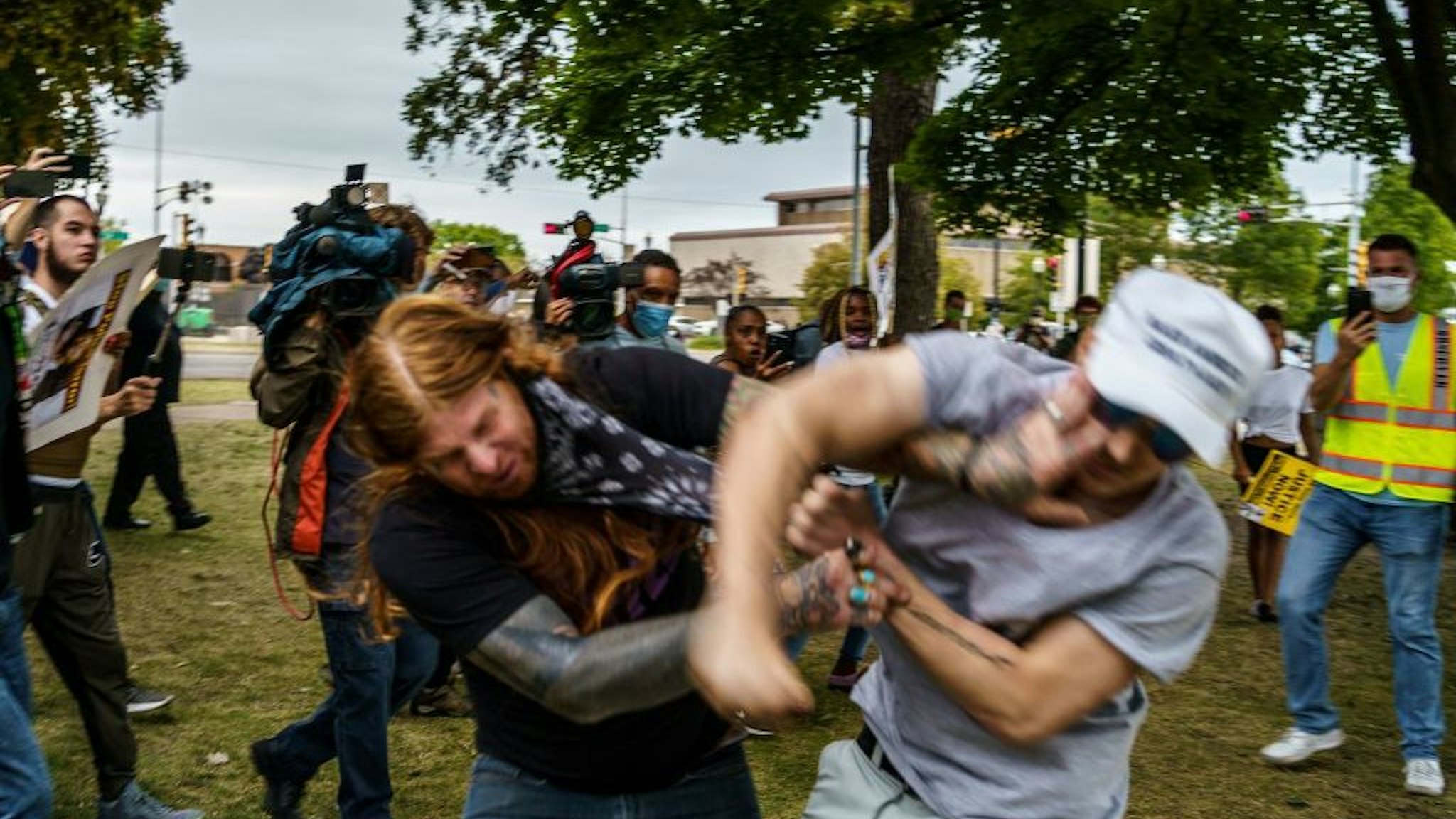 A protester scuffles with a Trump supporter (R) in Kenosha, Wisconsin, on September 1, 2020, amid ongoing demonstrations after the shooting by police of Jacob Blake. - President Donald Trump on September 1 took his tough law and order message to Kenosha, the latest US city roiled by the police shooting of a black man, as he branded recent anti-racism protests acts of "domestic terror" by violent mobs. (Photo by Kerem Yucel / AFP) (Photo by KEREM YUCEL/AFP via Getty Images)