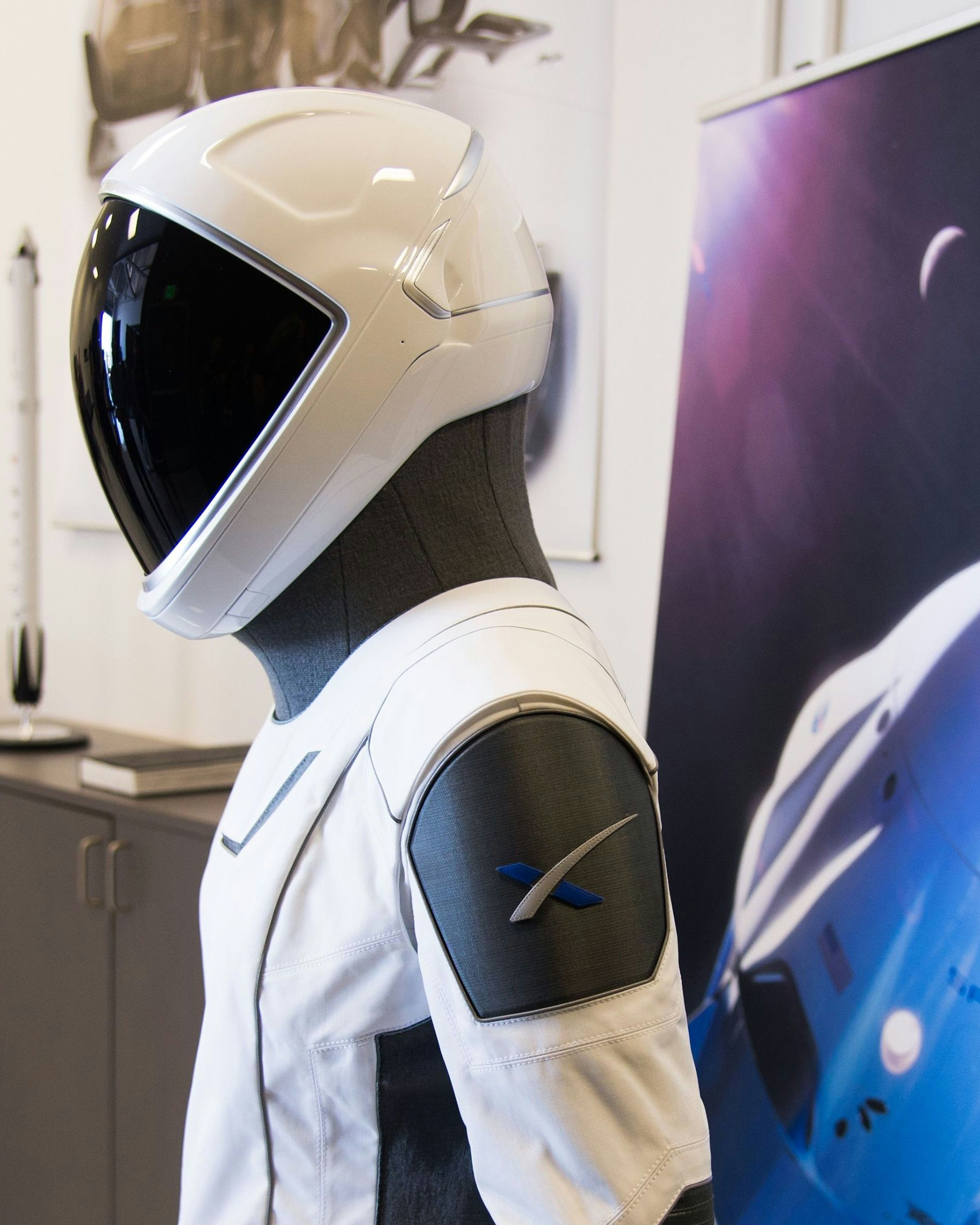 The SpaceX spacesuit to be wore by NASA astronauts that will travel to the International Space Station aboard the SpaceX Crew Dragon capsule is displayed during a media tour at SpaceX headquarters in Hawthorne, California, on August 13, 2018. - According to the Teslarati website the majority of the helmet is 3D printed and SpaceX has used that capability to directly integrate valves, a number of complex mechanisms for visor retraction and locking, microphones, and even air cooling channels into the helmets structure. The suit itself is designed so that necessary external connections (power, water, air, etc) all pass through one single umbilical panel located in the middle of the suit√ïs right thigh. The suit is designed to allow astronauts to work in extreme conditions including hard vacuum but not space walks. (Photo by Robyn Beck / AFP)