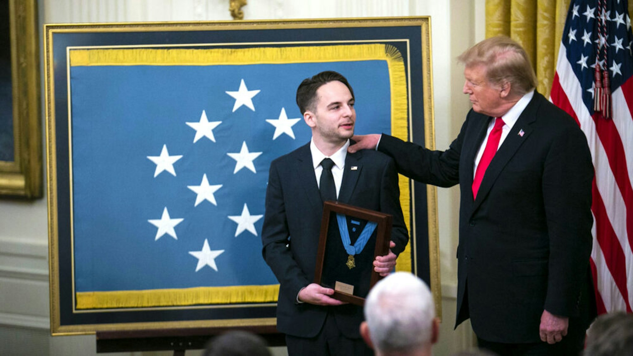 U.S. President Donald Trump, right, presents the Medal of Honor to Trevor Oliver, son of Staff Sergeant Travis Atkins, left, during a ceremony in the East Room of the White House in Washington, D.C., U.S., on Wednesday, March 27, 2019. Trump awarded the Medal of Honor posthumously to Staff Sergeant Travis Atkins, the first he bestowed to an Iraq War veteran.