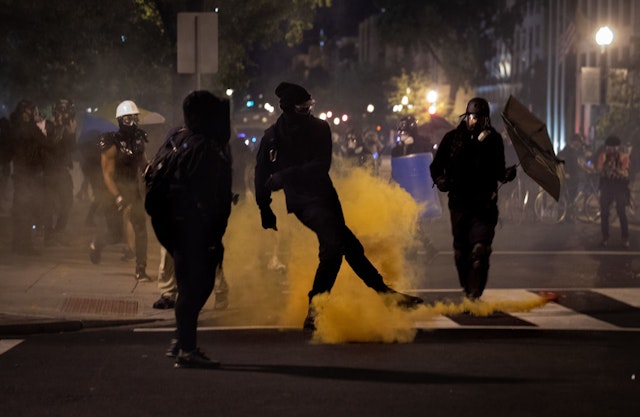 Protestors kick back gas canisters towards the police during demonstrations in Black Lives Matter Plaza, August 30th, 2020. (Photo by Evelyn Hockstein/For The Washington Post via Getty Images)