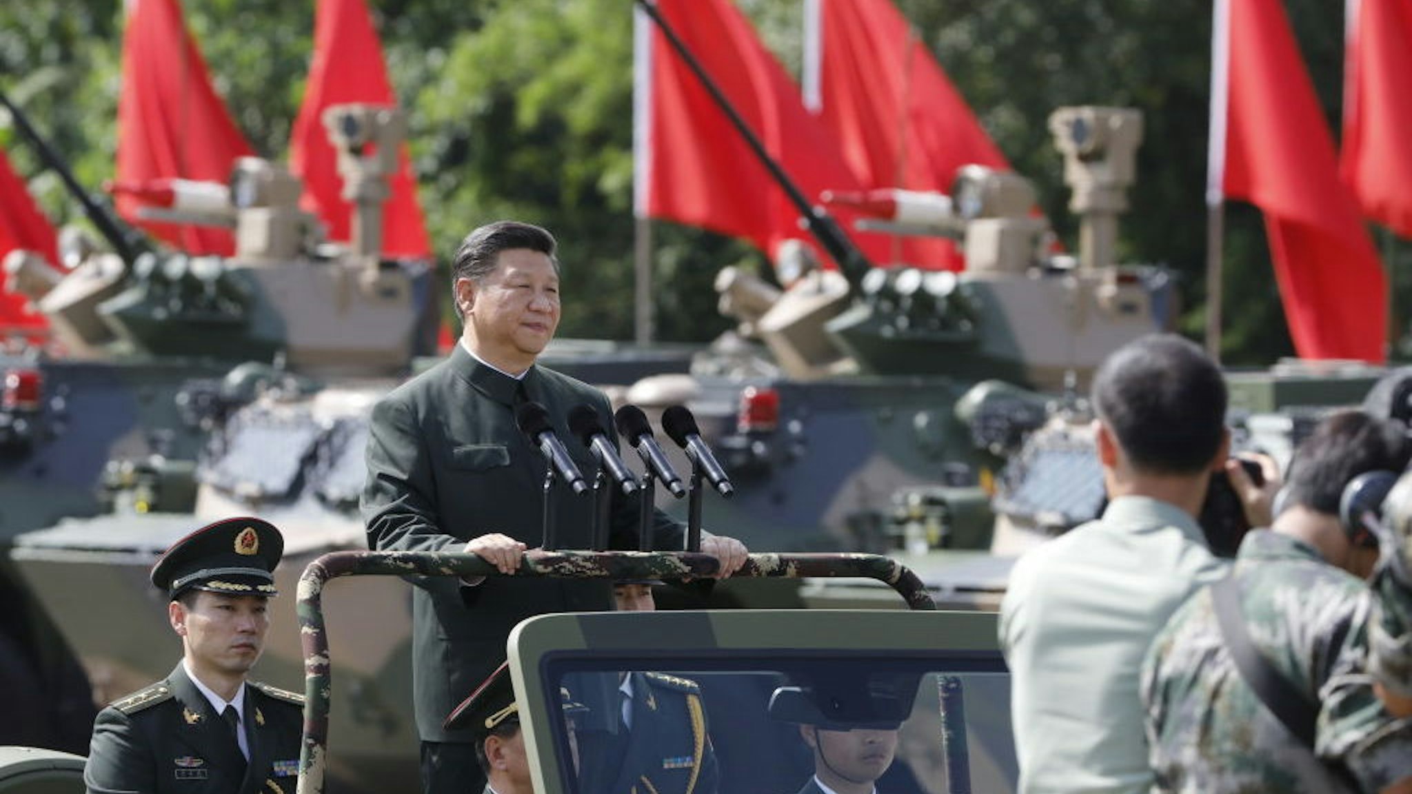 Xi Jinping, China's president, rides in a vehicle as he reviews People's Liberation Army (PLA) troops at the Shek Kong Barracks in Hong Kong, China, on Friday, June 30, 2017. Xi sought to reassure a divided Hong Kong of China’s continued support for the former British colony, as pro-democracy protesters struggled to be heard behind road blocks and police lines. Photographer: Anthony Kwan/Bloomberg