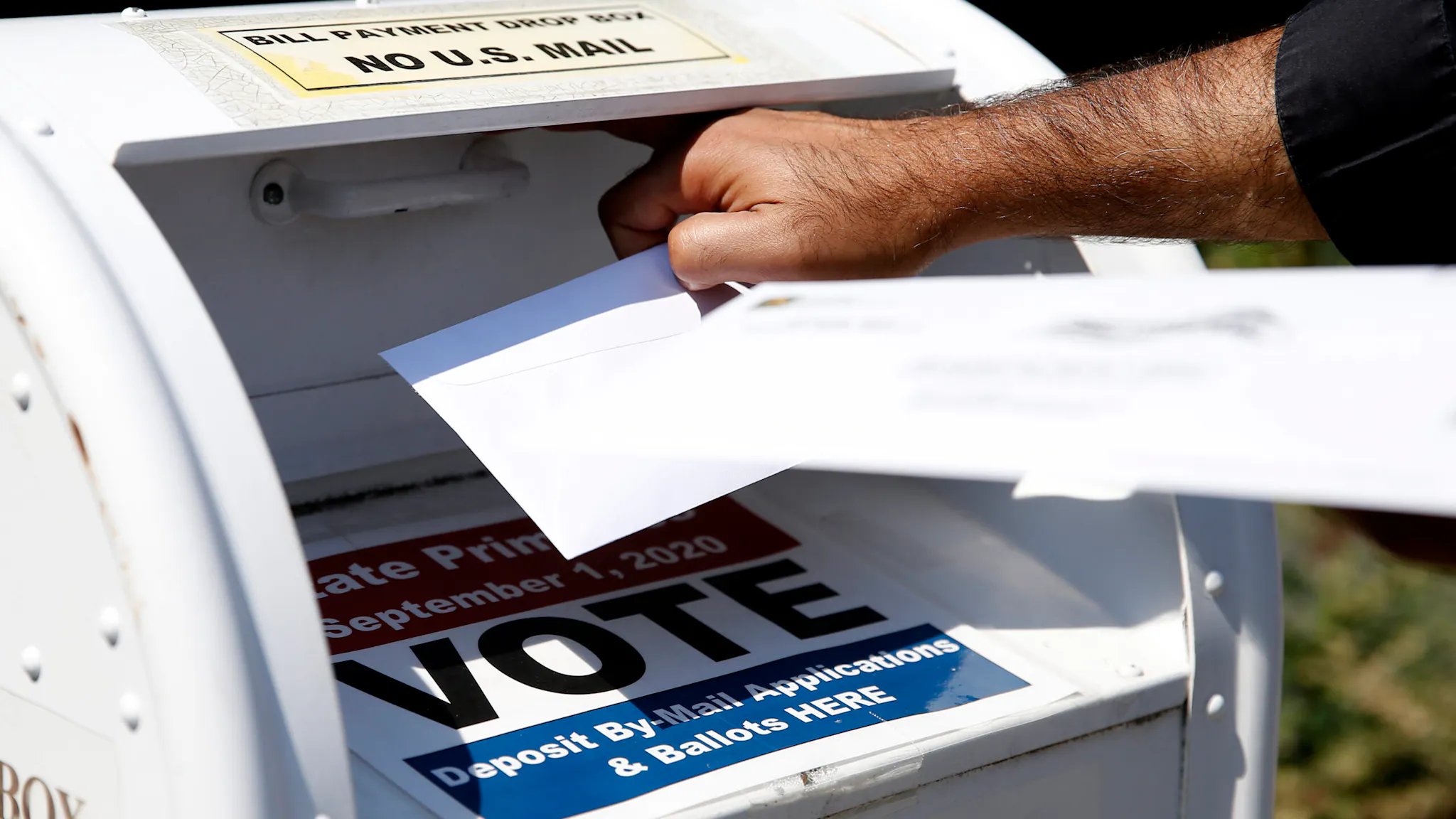 Candidates For Congress in Massachusetts’ Fourth Congressional District Attend Rally For Affordable Housing NEWTON - AUGUST 23: A voter drops a ballot into the box for mail-in ballots outside of Newton City Hall in Newton, MA on Aug. 23, 2020, where there's a crowded field in the primary race for the fourth Congressional Democratic nomination.