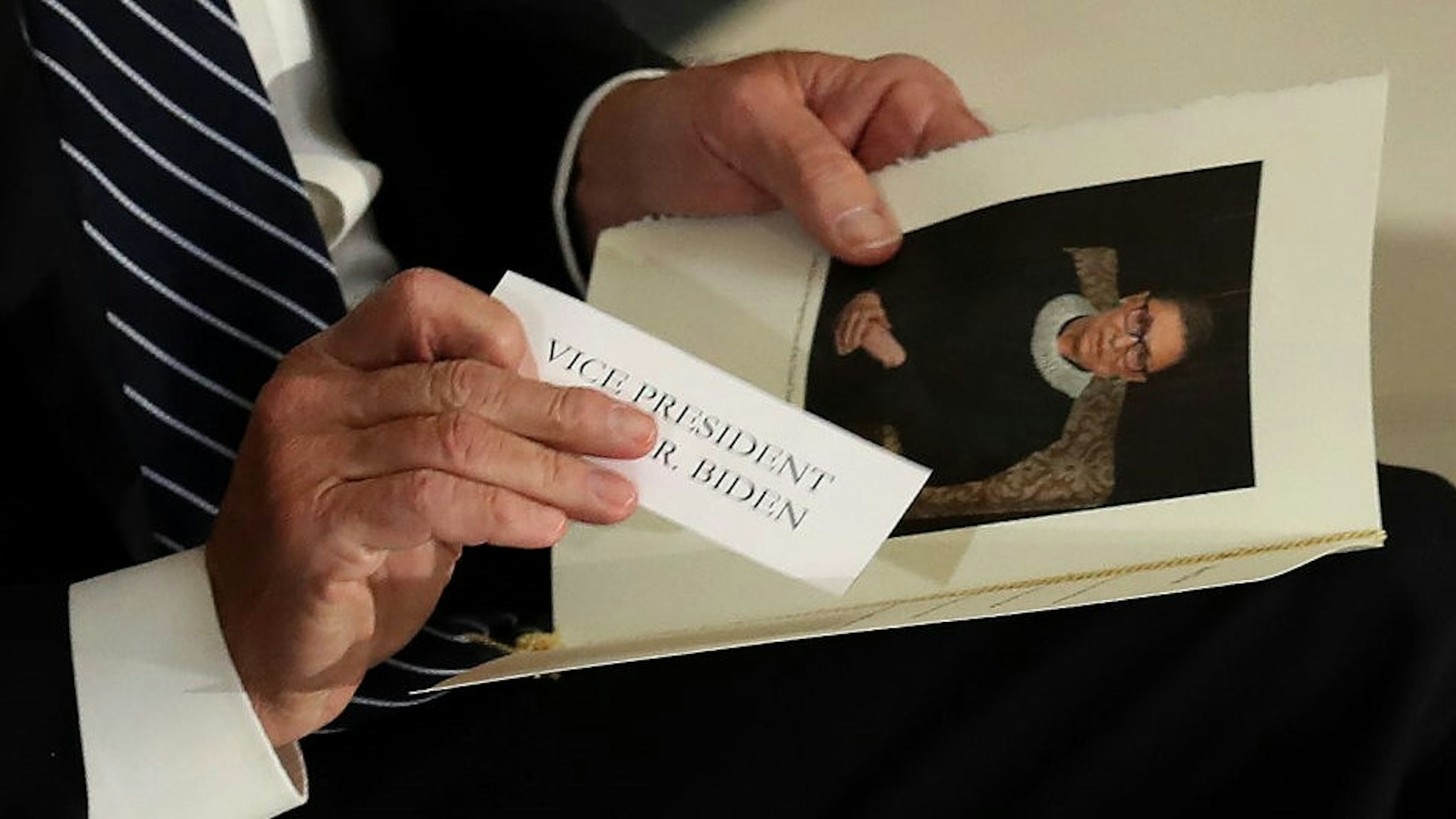 Former Vice President and Democratic presidential nominee Joe Biden puts his name tag into his program during a memorial for the late Associate Justice Ruth Bader Ginsburg in the Statuary Hall, where she lies in state at the US Capitol, September 25, 2020 in Washington, DC. (Photo by Chip Somodevilla / POOL / AFP) (Photo by