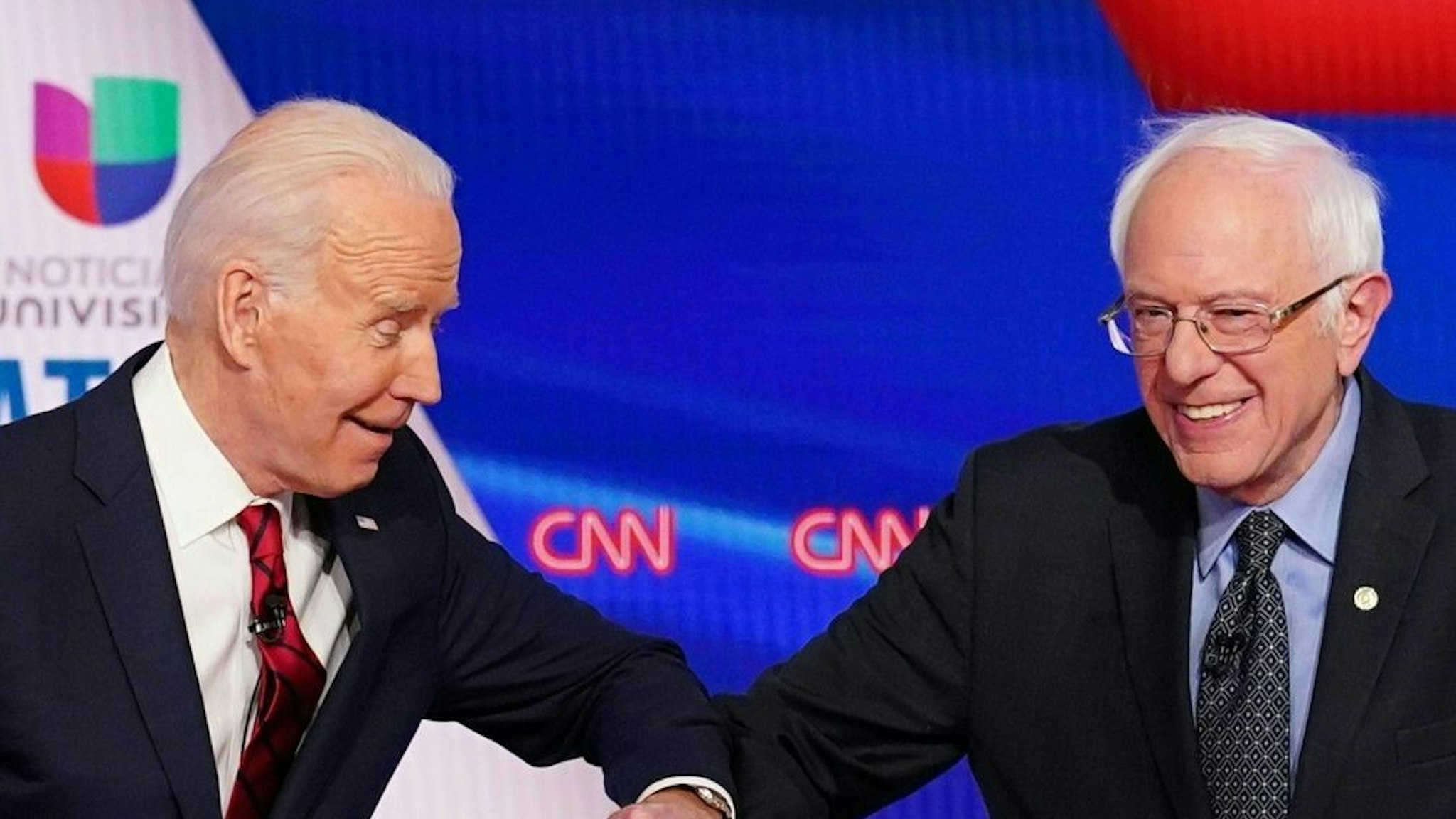 TOPSHOT - Democratic presidential hopefuls former US vice president Joe Biden (L) and Senator Bernie Sanders greet each other with a safe elbow bump before the start of the 11th Democratic Party 2020 presidential debate in a CNN Washington Bureau studio in Washington, DC on March 15, 2020. (Photo by Mandel NGAN / AFP) (Photo by