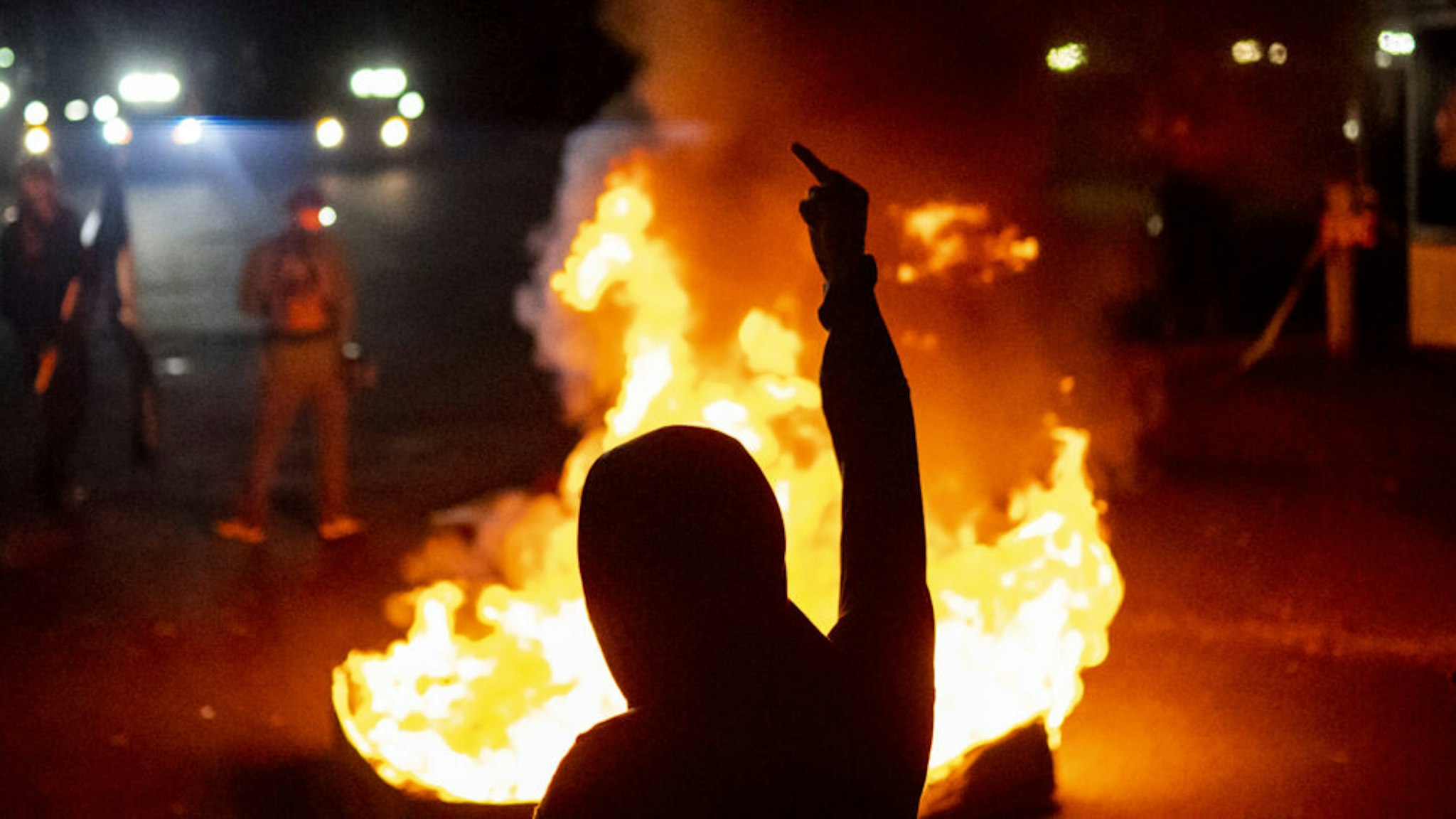 PORTLAND OR - SEPTEMBER 6: Protesters chant in front of a fire near the North police precinct during a protest against racial injustice and police brutality on September 6, 2020 in Portland, Oregon. Sunday marked the 101st consecutive night of protests in Portland.