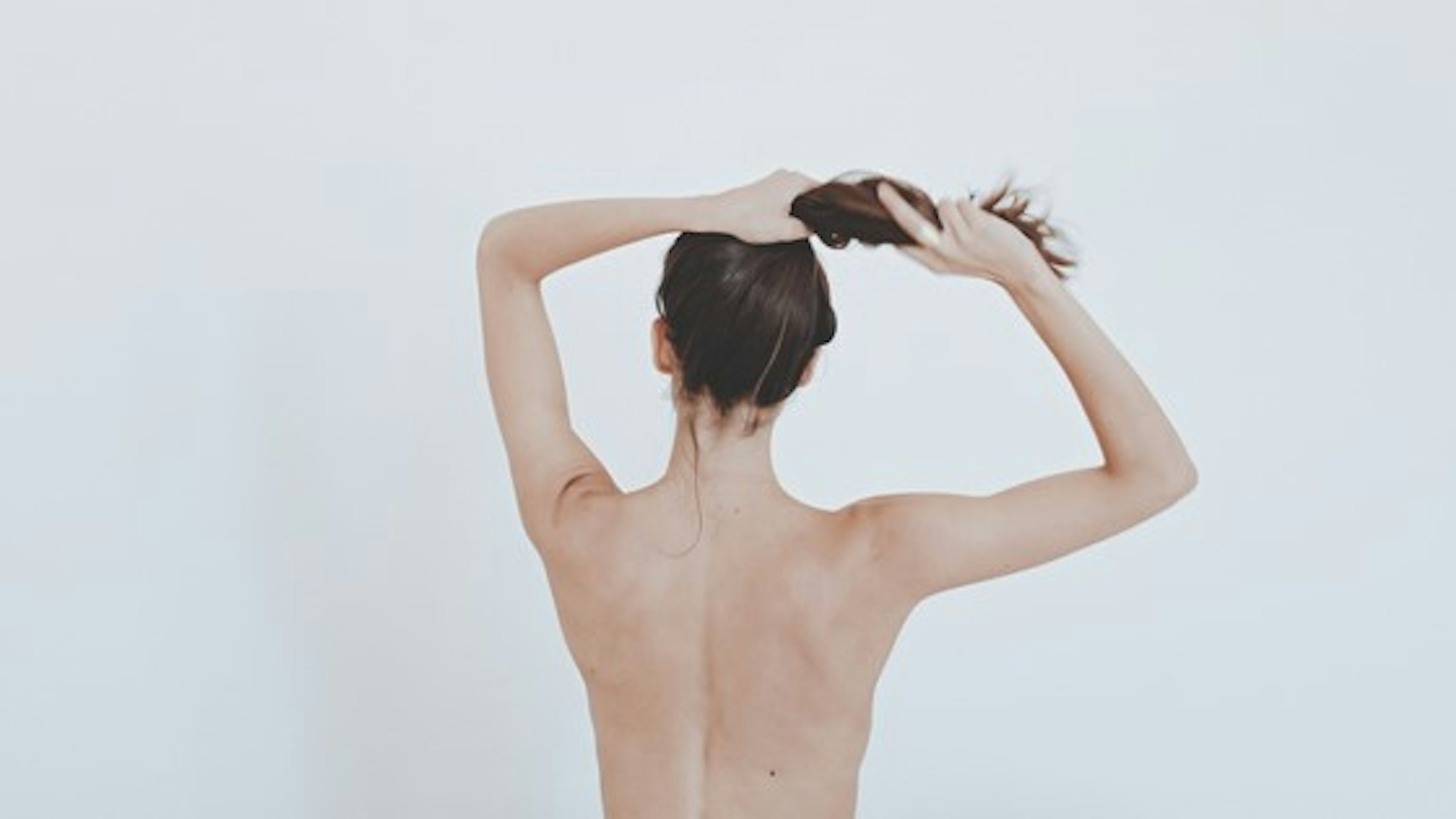 Rear View Of Young Woman Against White Background