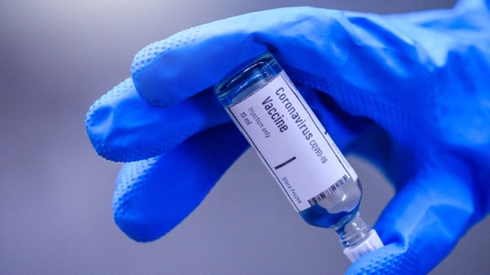 Image of Hand holds Coronavirus Covid-19 Vaccine glass bottle