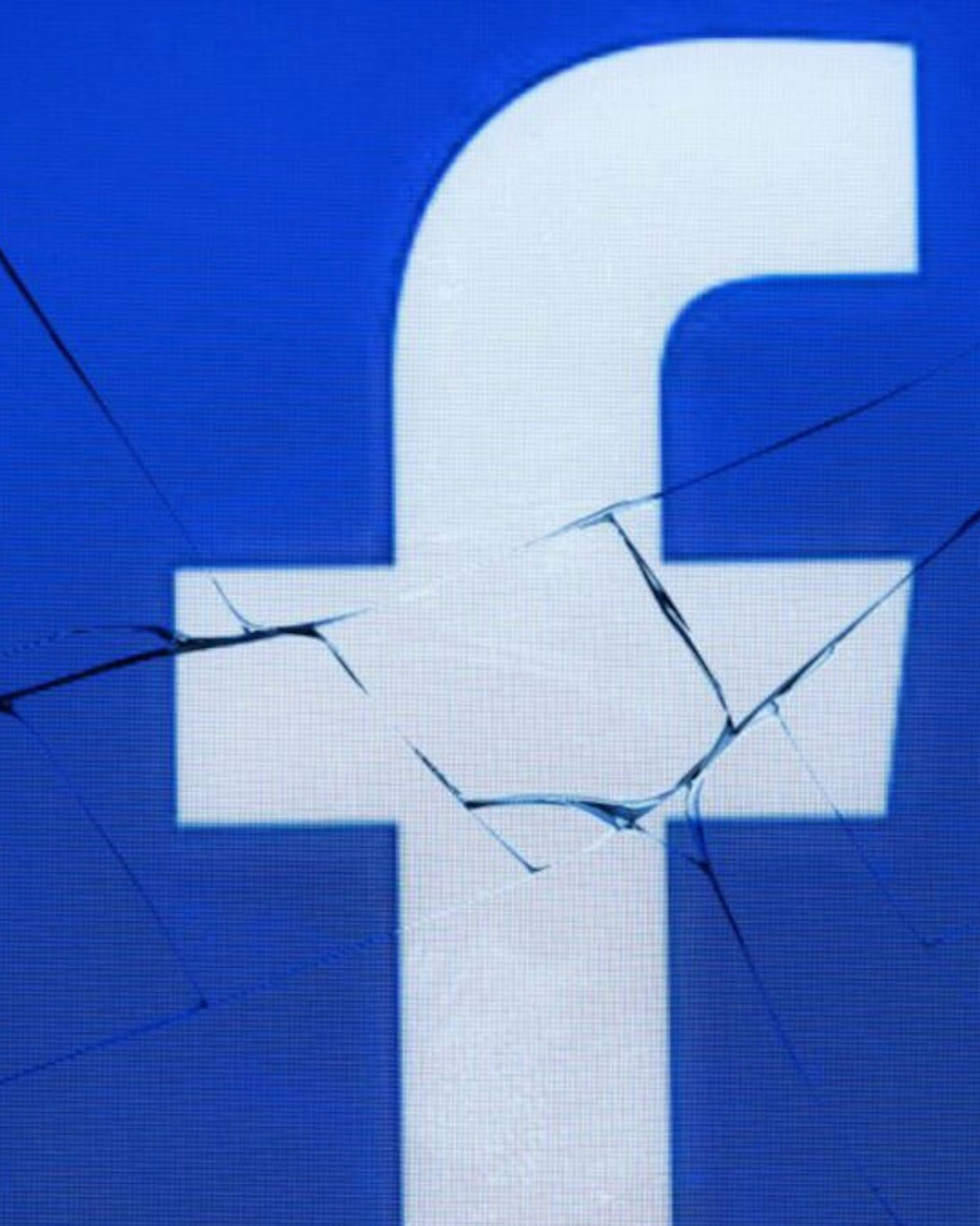A picture taken in Paris on May 16, 2018 shows the logo of the social network Facebook on a broken screen of a mobile phone.