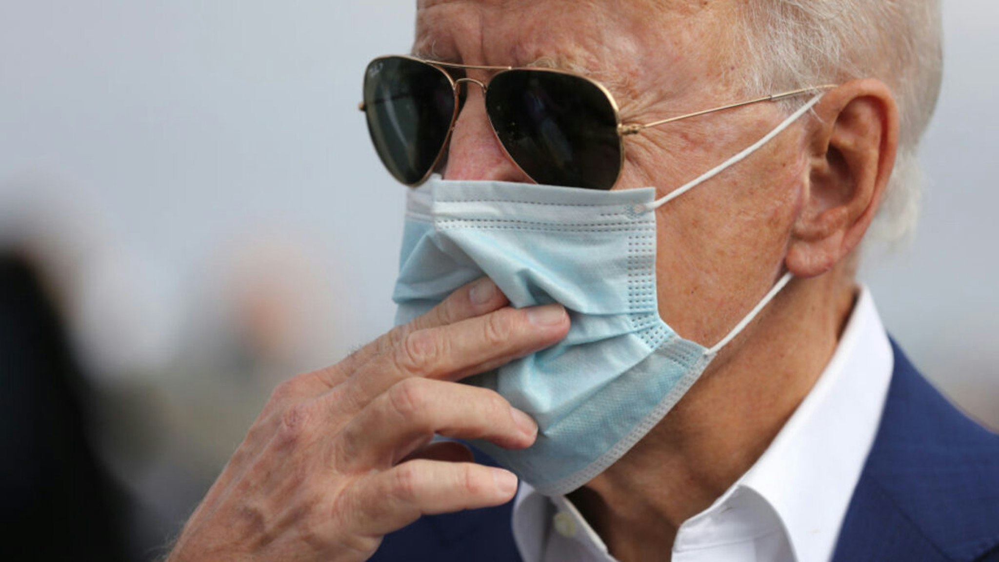 Wearing a face mask to reduce the risk posed by the coronavirus, Democratic presidential nominee Joe Biden speaks briefly with reporters before boarding a flight to Florida at New Castle County Airport October 13, 2020 in New Castle, Delaware.