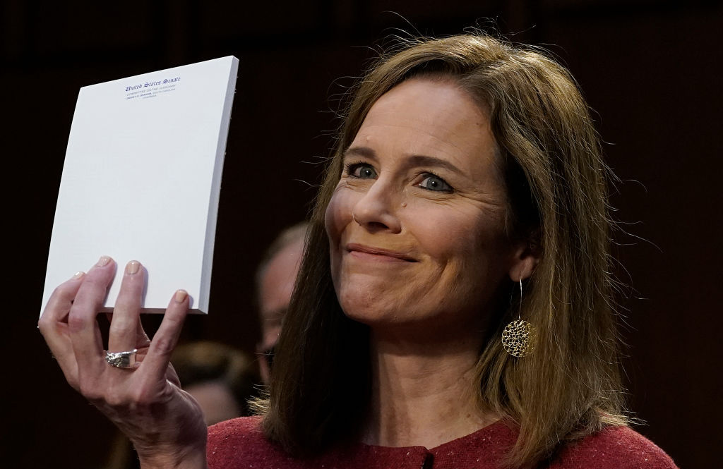 Judge Amy Coney Barrett, holds up a blank notepad after Senator John Cornyn asked her what documents she had on her desk during the second day of her Senate confirmation hearing to the Supreme Court on Capitol Hill in Washington, DC on October 13, 2020. - President Donald Trump's US Supreme Court nominee Amy Coney Barrett faces a sharply divided Senate October 13, 2020 for her first question-and-answer session, with Republicans praising her faith and qualifications and Democrats set to bombard her over healthcare. (Photo by Drew Angerer / POOL / AFP)