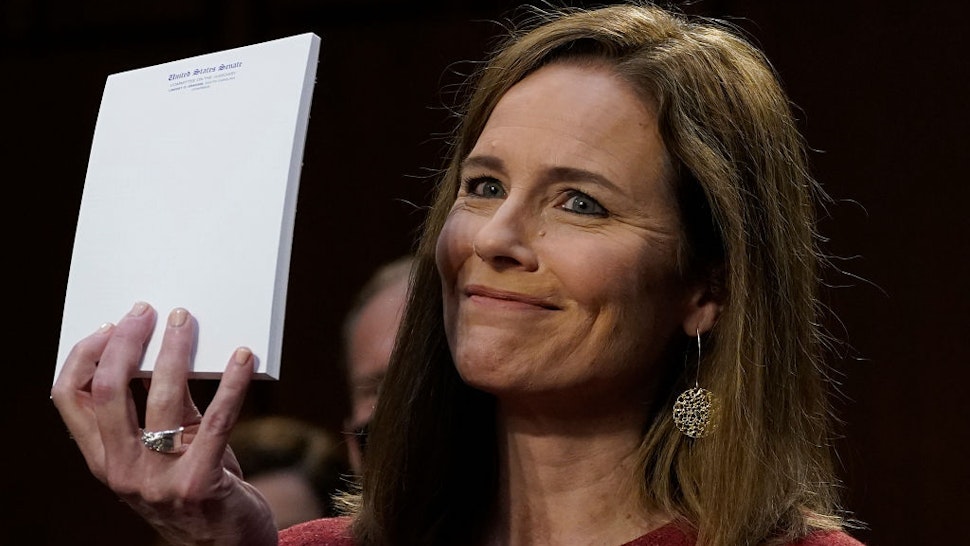 Judge Amy Coney Barrett, holds up a blank notepad after Senator John Cornyn asked her what documents she had on her desk during the second day of her Senate confirmation hearing to the Supreme Court on Capitol Hill in Washington, DC on October 13, 2020. - President Donald Trump's US Supreme Court nominee Amy Coney Barrett faces a sharply divided Senate October 13, 2020 for her first question-and-answer session, with Republicans praising her faith and qualifications and Democrats set to bombard her over healthcare. (Photo by Drew Angerer / POOL / AFP)