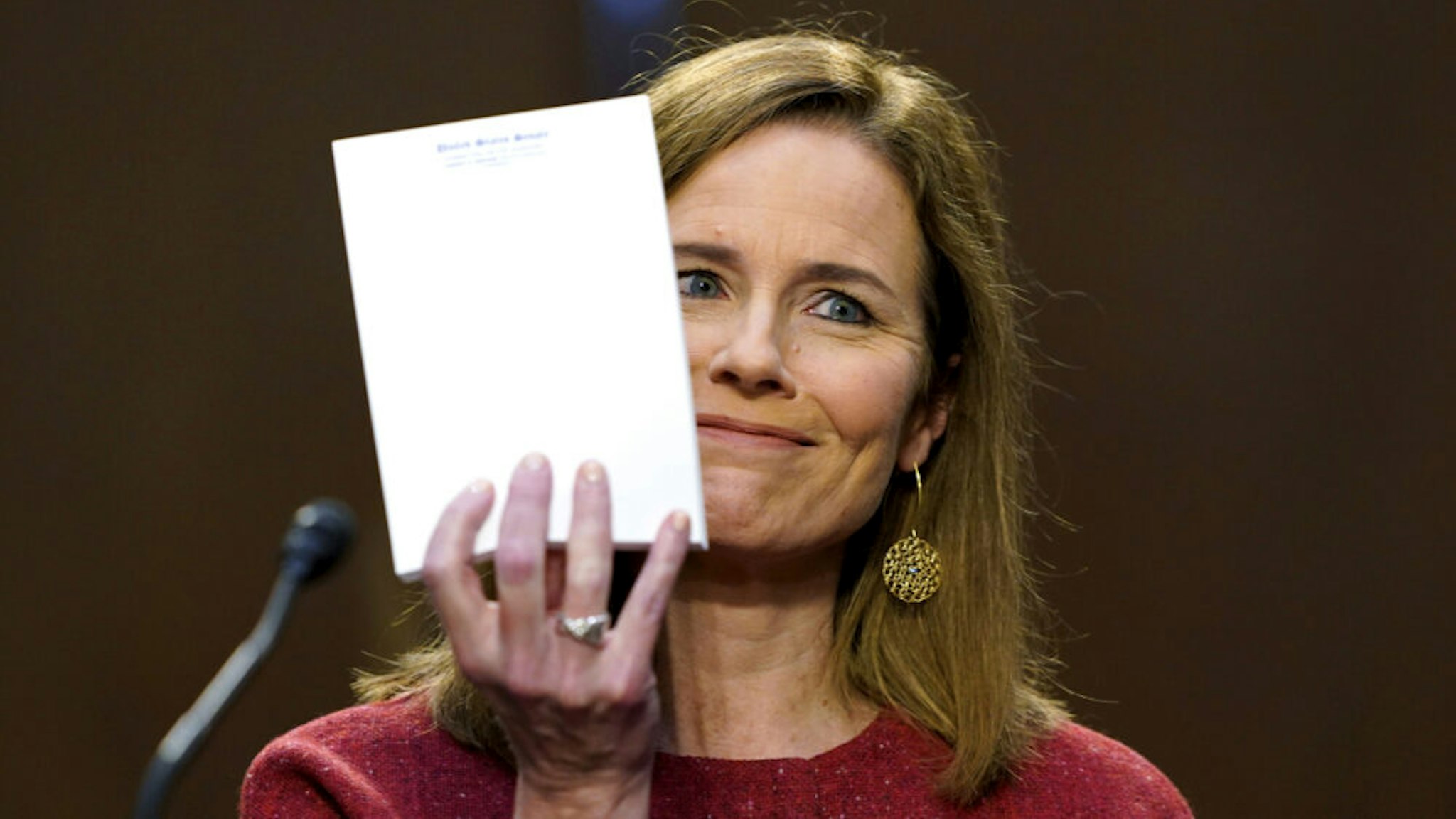 WASHINGTON, DC - OCTOBER 13: Supreme Court nominee Judge Amy Coney Barrett holds up a note pad on the second day of her Supreme Court confirmation hearing before the Senate Judiciary Committee on Capitol Hill on October 13, 2020 in Washington, DC. With less than a month until the presidential election, President Donald Trump tapped Amy Coney Barrett to be his third Supreme Court nominee in just four years. If confirmed, Barrett would replace the late Associate Justice Ruth Bader Ginsburg.