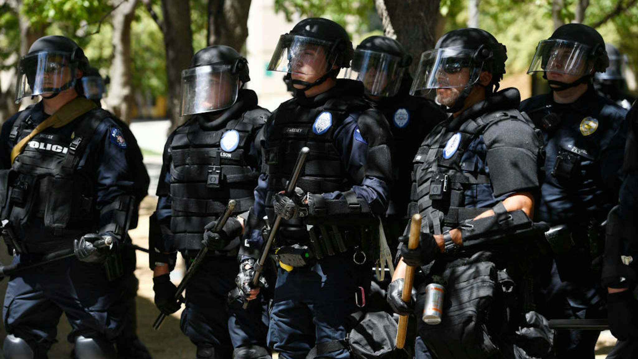 AURORA, CO - JUNE 27: Aurora police in full riot gear at the ready behind a police fence during a Elijah McClain protest in front of the Aurora Police department's headquarters at the Aurora Municipal Center June 27, 2020. Elijah McClain died August 30, 2019 several days after a struggle with Aurora police. Elijah became unconscious during the encounter with police August 24, 2019 and had a heart attack while being transported to a hospital. McClain died after being taken off life support. (Photo by Andy Cross/The Denver Post)