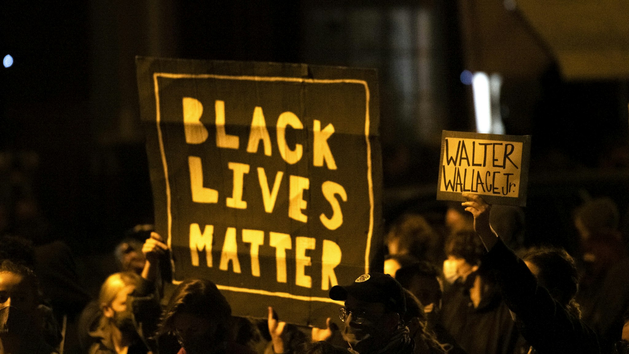 PHILADELPHIA, PA - OCTOBER 27: Demonstrators holding placards reading "BLACK LIVES MATTER" and "WALTER WALLACE JR." during a protest near the location where Walter Wallace, Jr. was killed by two police officers on October 27, 2020 in Philadelphia, Pennsylvania. Protests erupted after the fatal shooting of 27-year-old Wallace Jr, who Philadelphia police officers claimed was armed with a knife.
