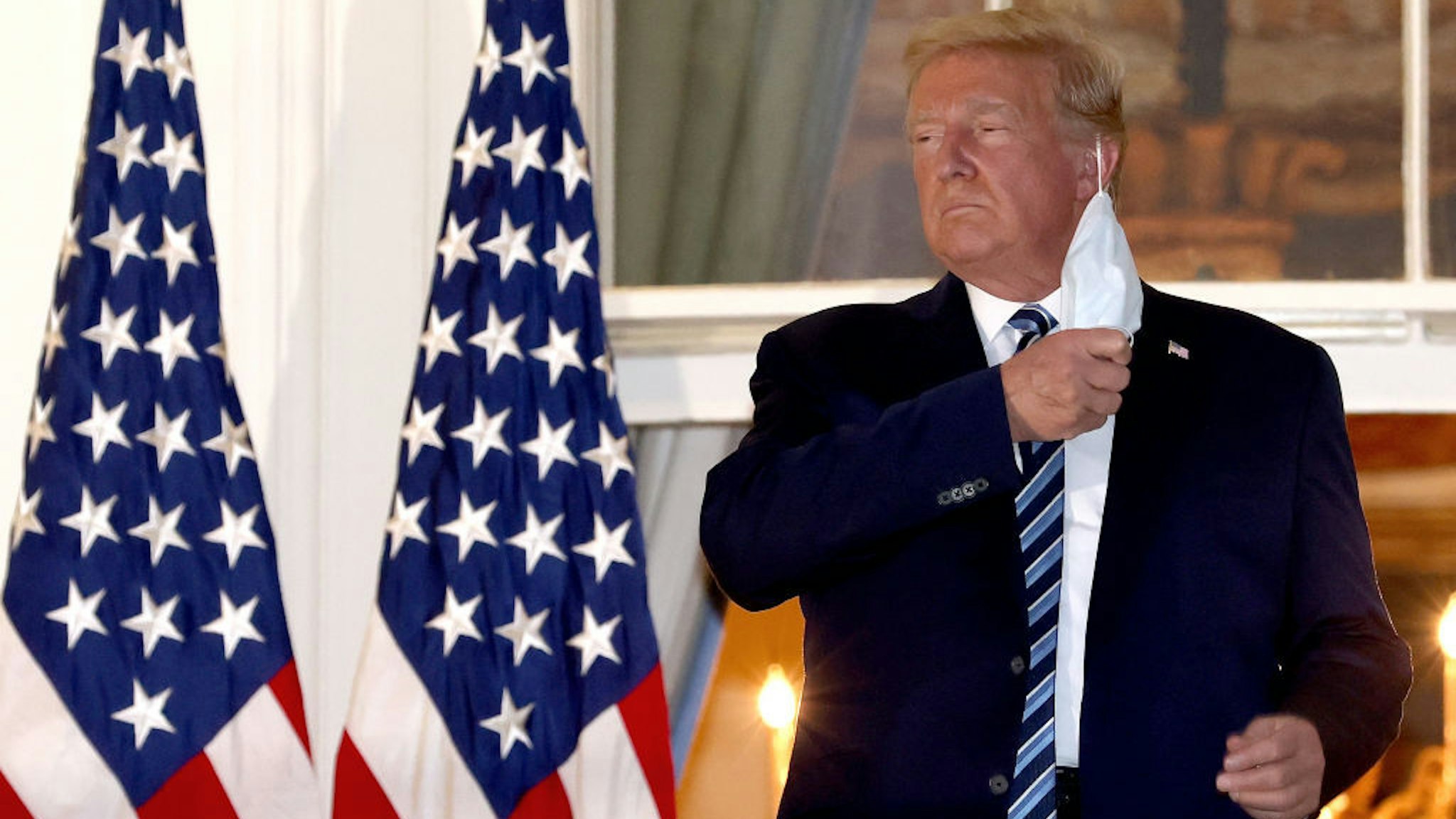 U.S. President Donald Trump removes his mask upon return to the White House from Walter Reed National Military Medical Center on October 05, 2020 in Washington, DC. Trump spent three days hospitalized for coronavirus. (Photo by Win McNamee/Getty Images)