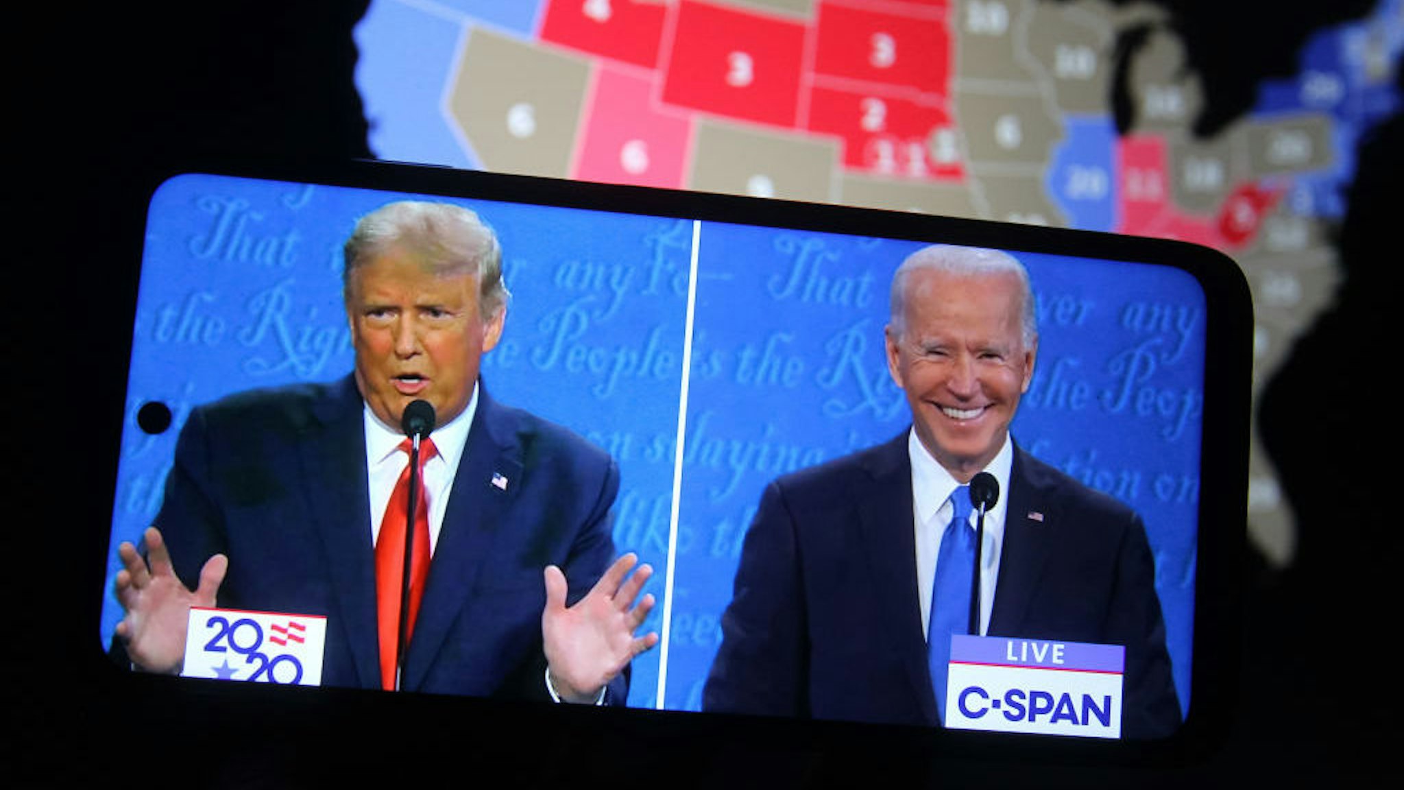In this photo illustration the US President Donald Trump and Democratic presidential candidate and former US Vice President Joe Biden are seen during the final presidential debate displayed on a screen of a smartphone. The final presidential debate between President Donald Trump and former Vice President Joe Biden took place at Belmont University in Nashville, the U.S. on Thursday, October 22. United States presidential election scheduled for November 3, 2020. (Photo Illustration by Pavlo Conchar/SOPA Images/LightRocket via Getty Images)