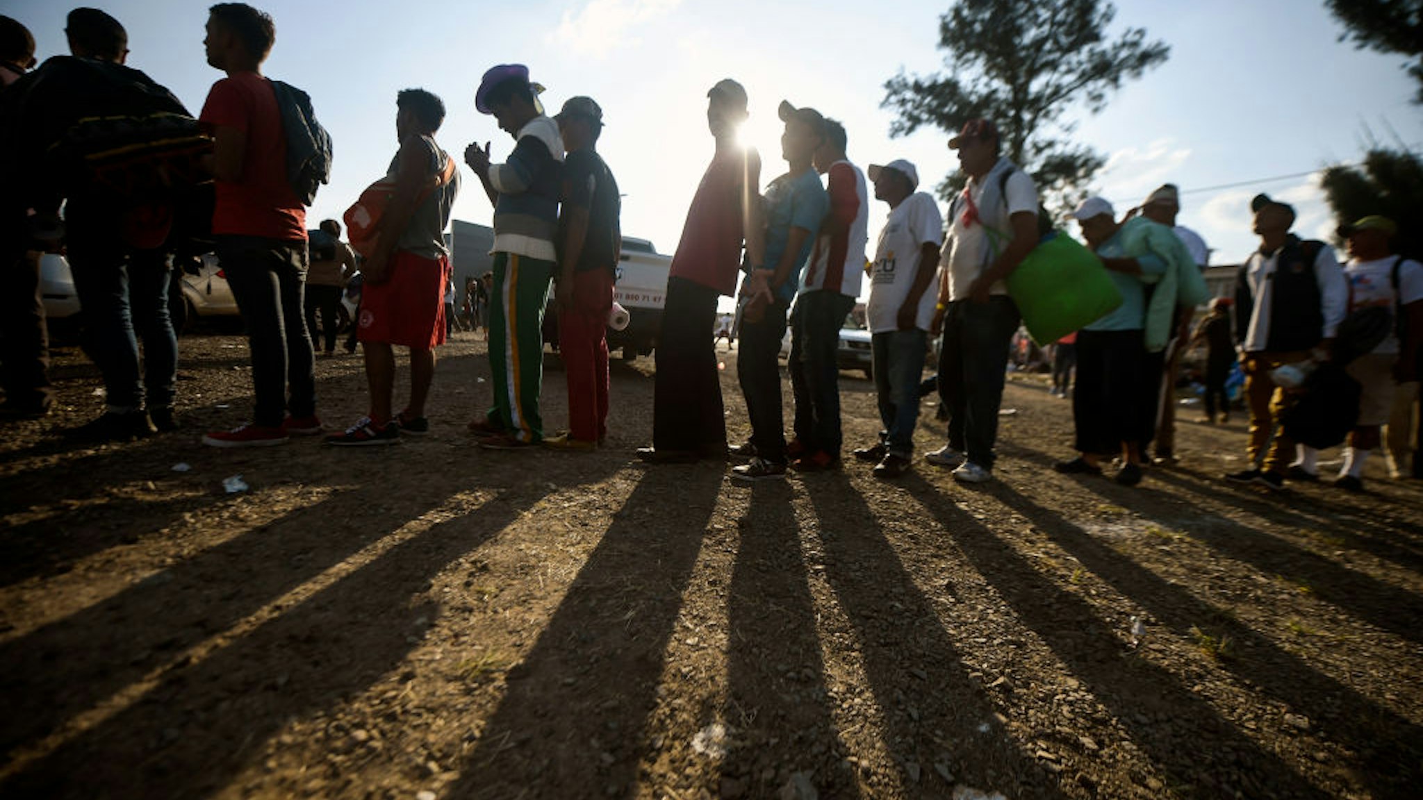 Central American migrants, taking part in a caravan heading to the US, queue to receive a meal at a temporary shelter in Irapuato, Guanajuato state, Mexico on November 11, 2018. - The trek from tropical Central America to the huge capital of Mexico is declining the health of the migrant caravan that endures extreme climate changes, as well as overcrowding and physical exhaustion, and still has to face the desert that leads to the United States. (Photo by ALFREDO ESTRELLA / AFP) (Photo credit should read ALFREDO ESTRELLA/AFP via Getty Images)