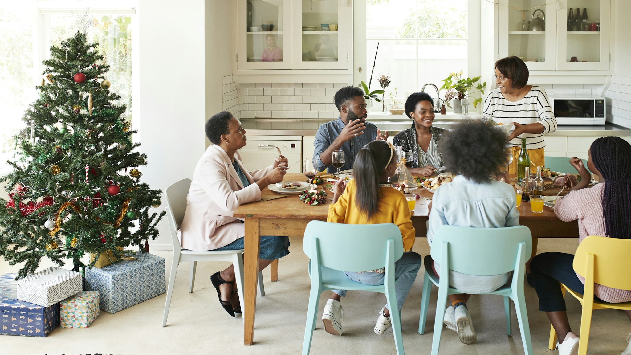 Family and friends talking while enjoying meal - stock photo