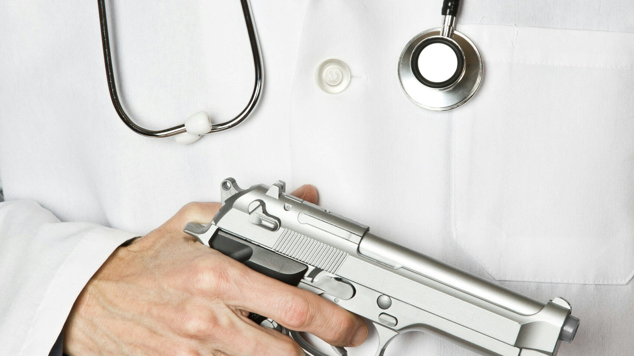 Doctor holding handgun - stock photo